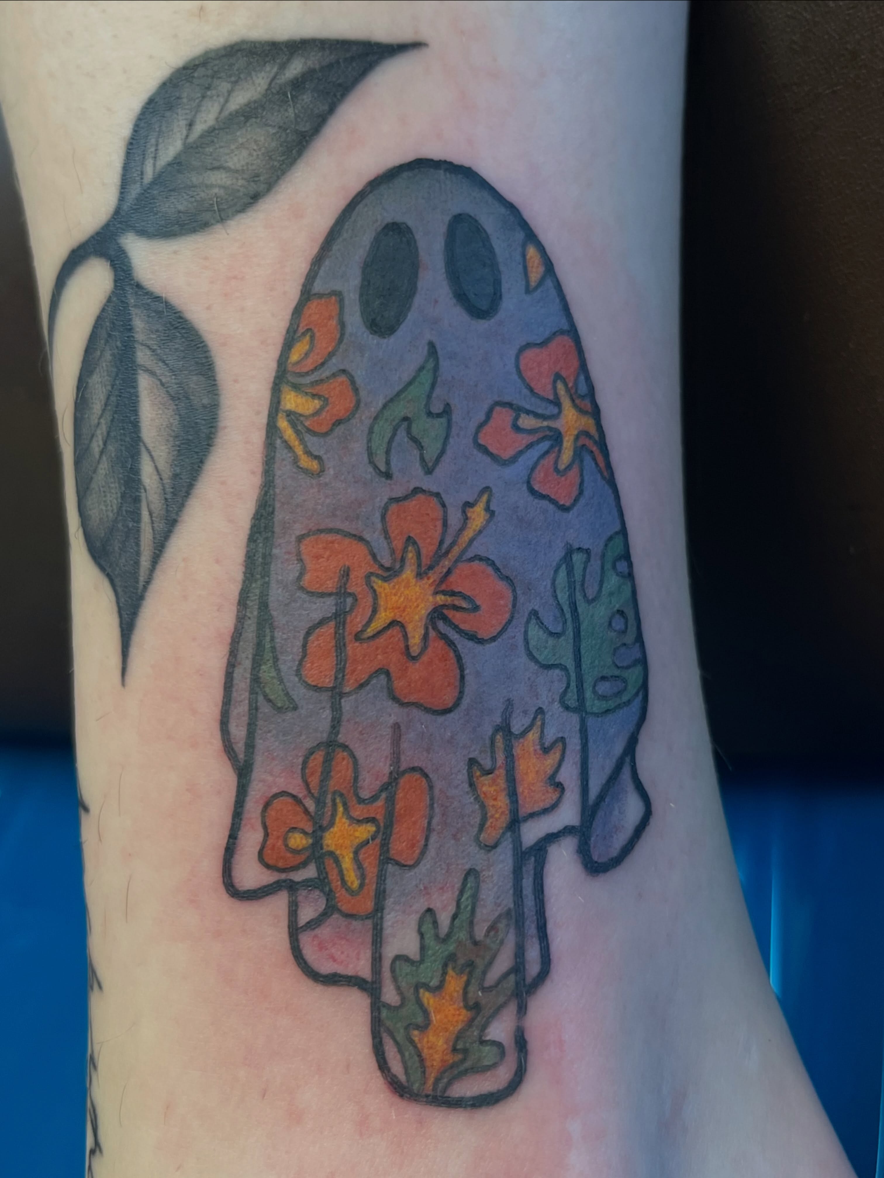Ghost with floral pattern watercolor tattoo on the forearm by Danielle Lorandeau