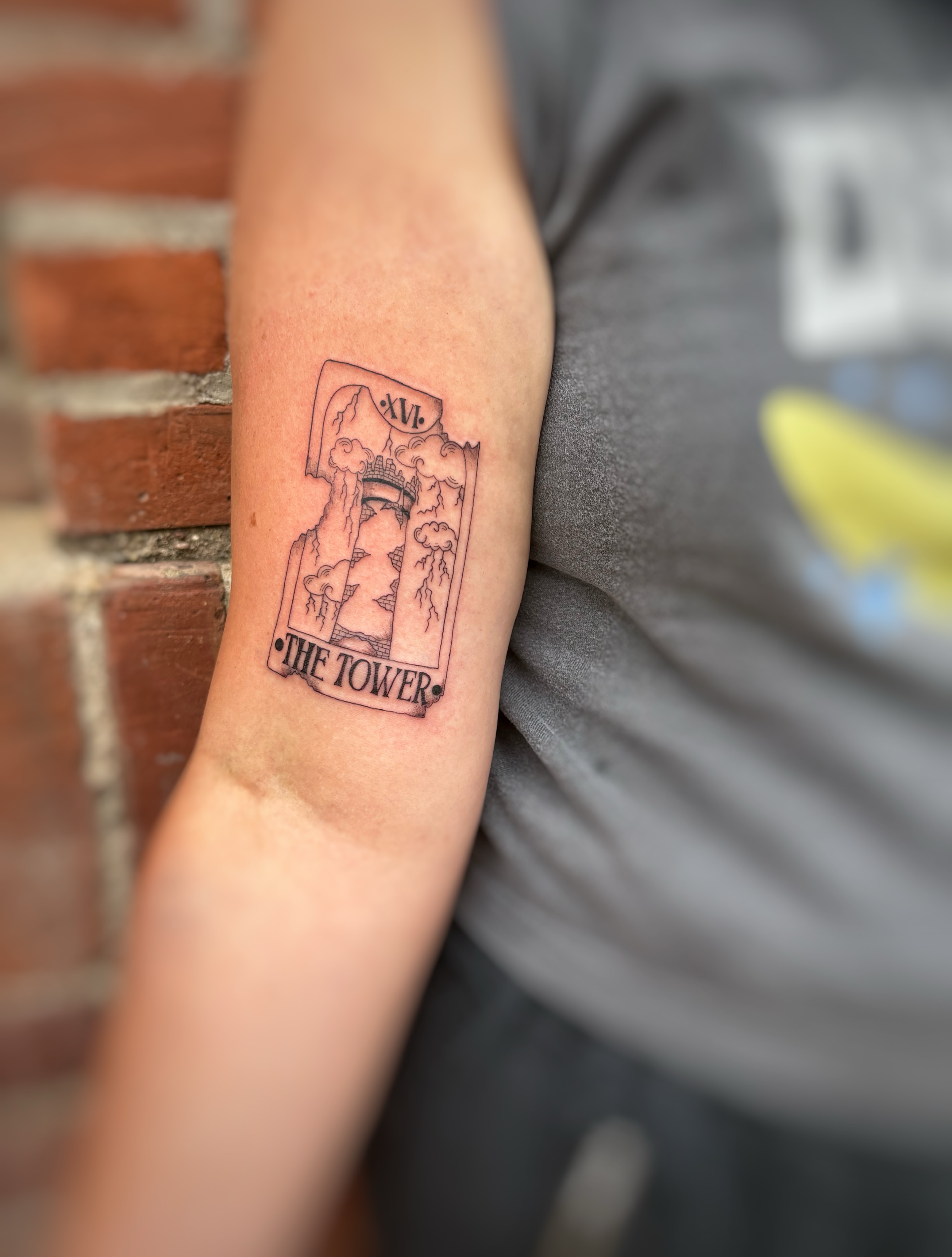 The tower tarot card black and grey tattoo on the forearm by Holly