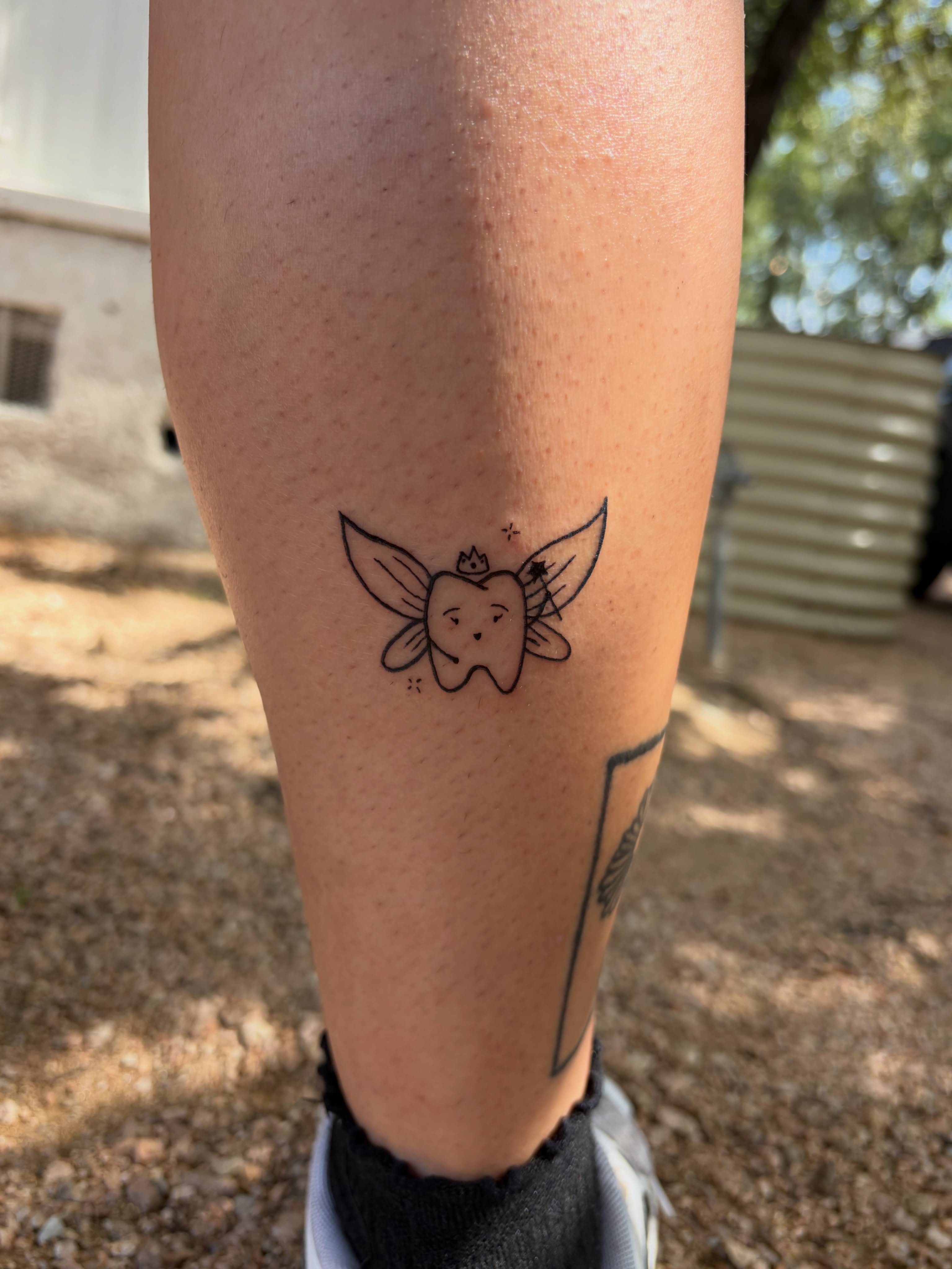Tooth with wings minimalist tattoo on the forearm by Inky Birdz Tattoos