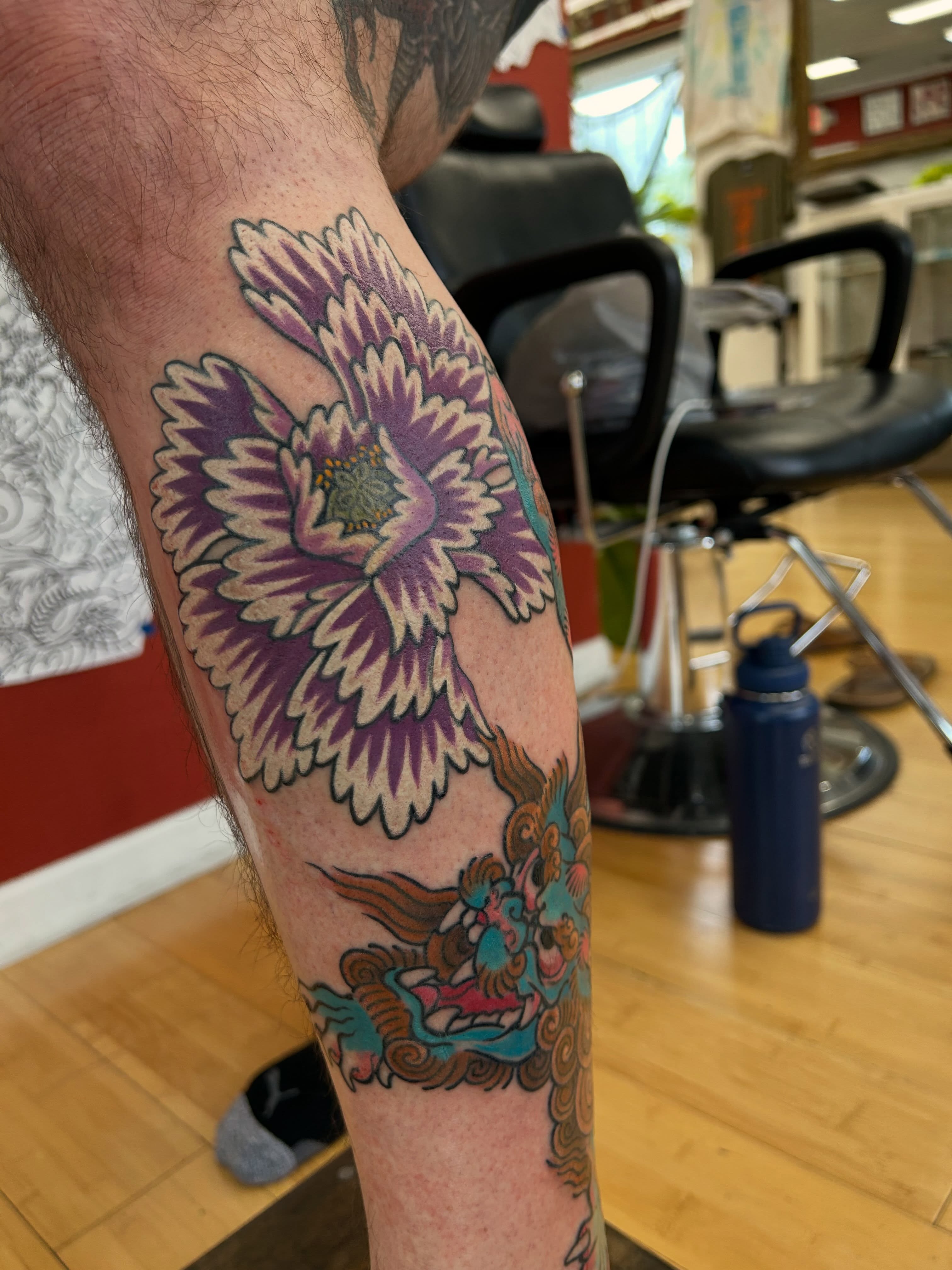 Floral phoenix American traditional tattoo on the forearm by Matthew Crimson