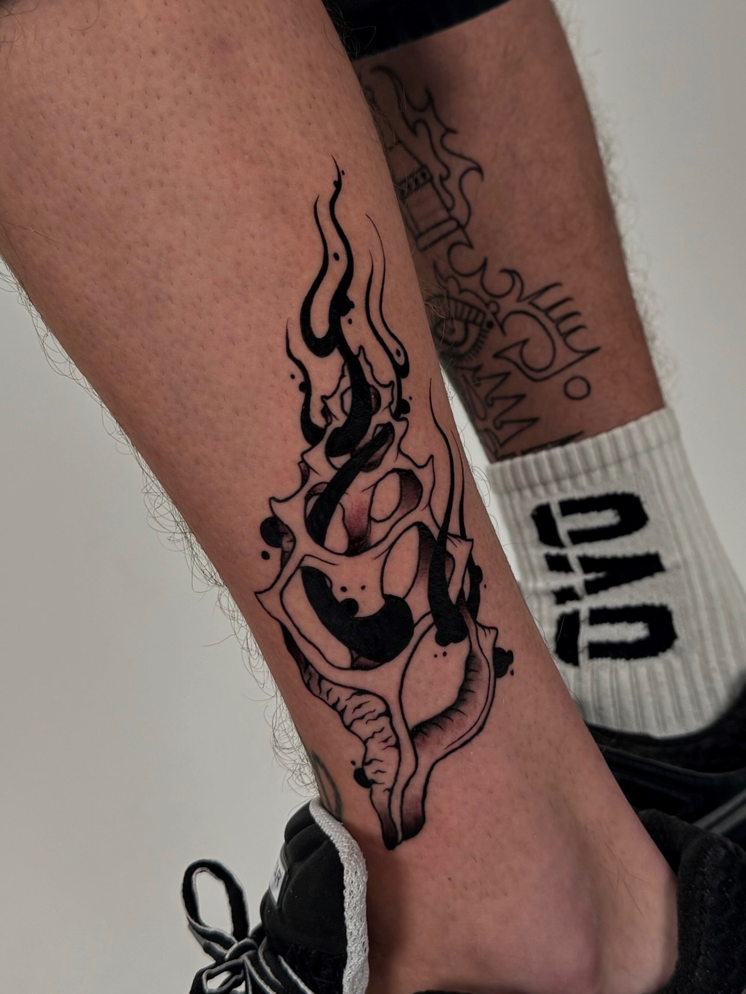 Flame and skull black and grey tattoo on the forearm by Rebel milly Tattoo