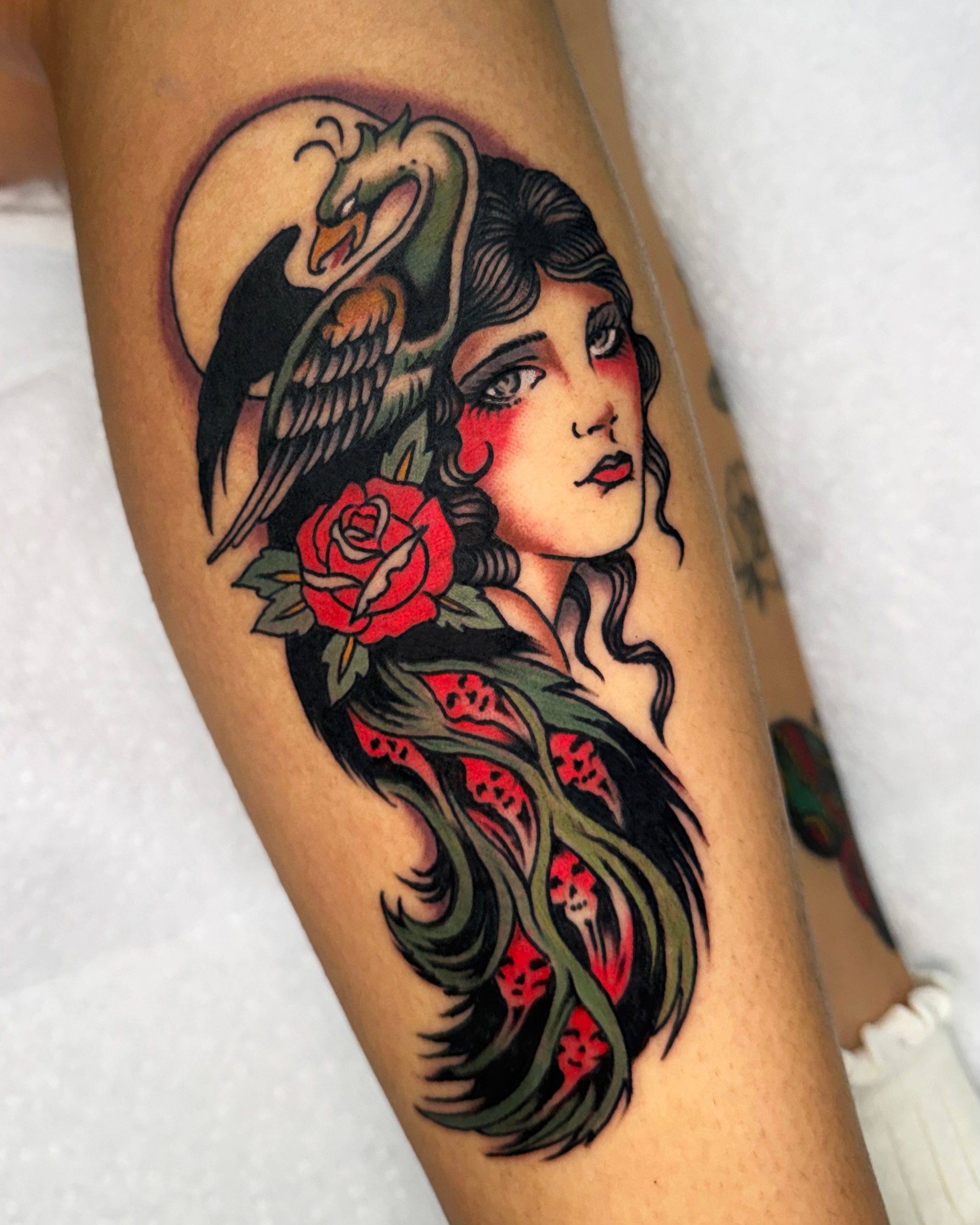 Woman with swan and roses American traditional tattoo on the forearm by Haley Tucker, Sebastopol, California