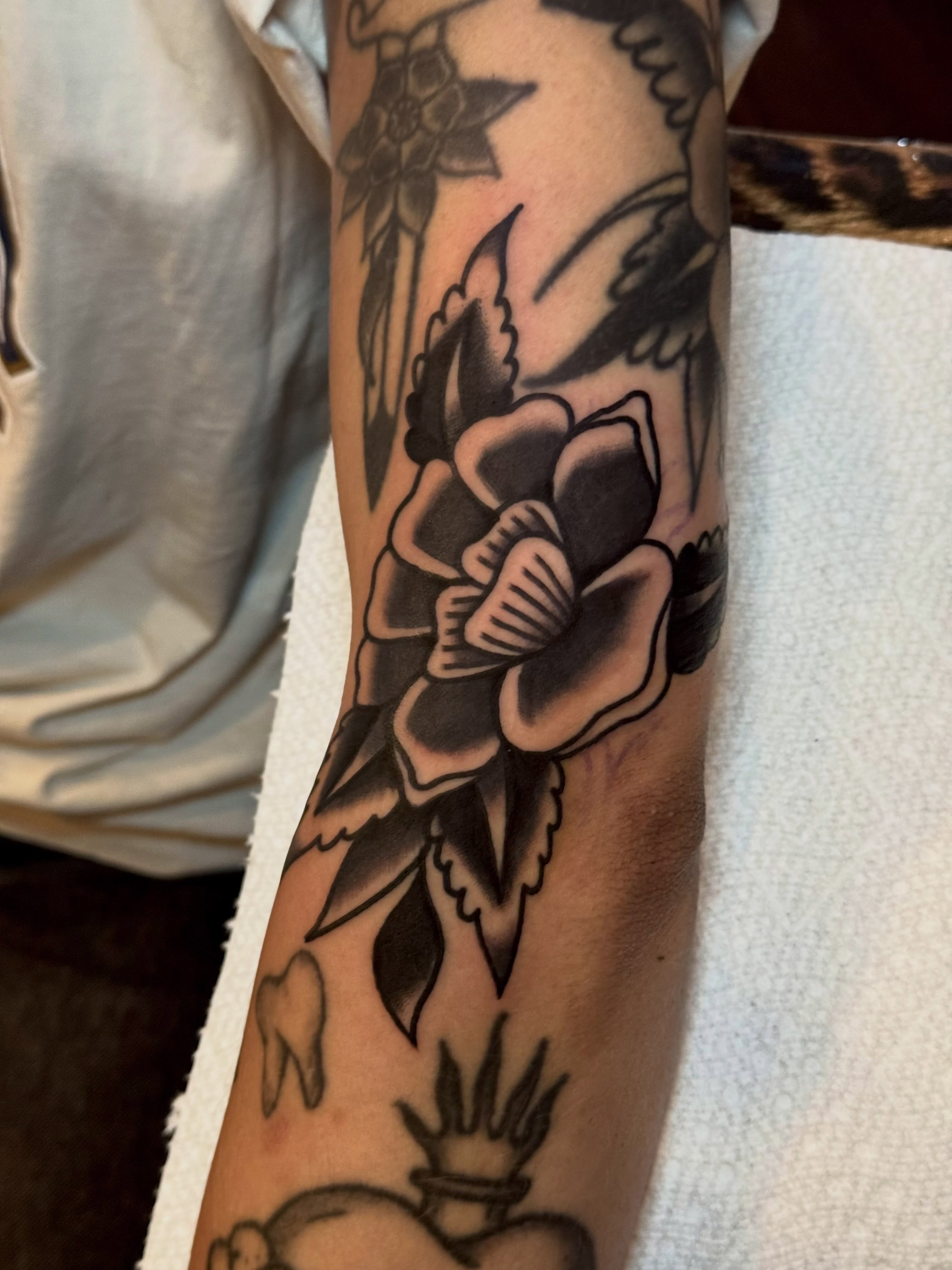 Flower and dagger American traditional tattoo on the forearm by Eli Bernal