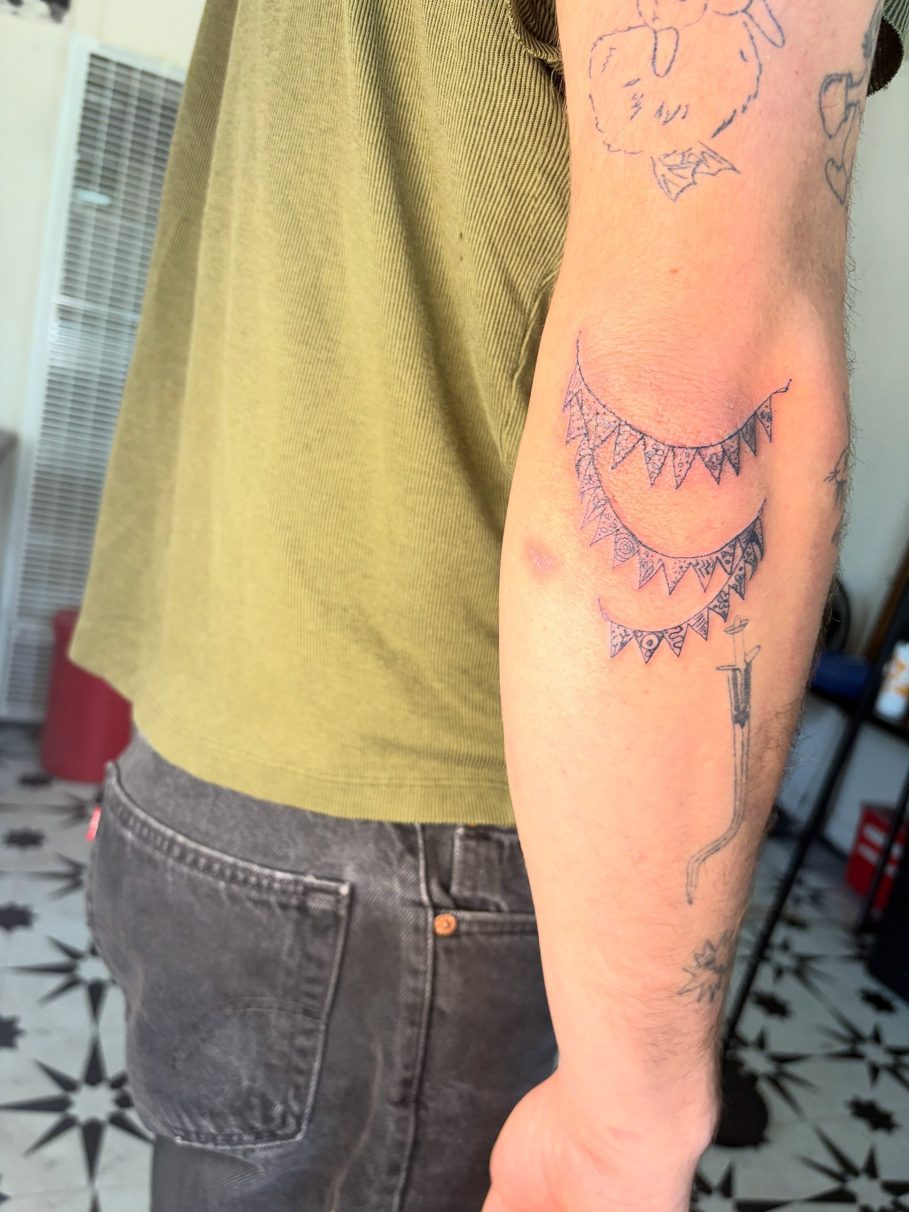 Sun and crescent moon geometric tattoo on the forearm by Mattie Robinson