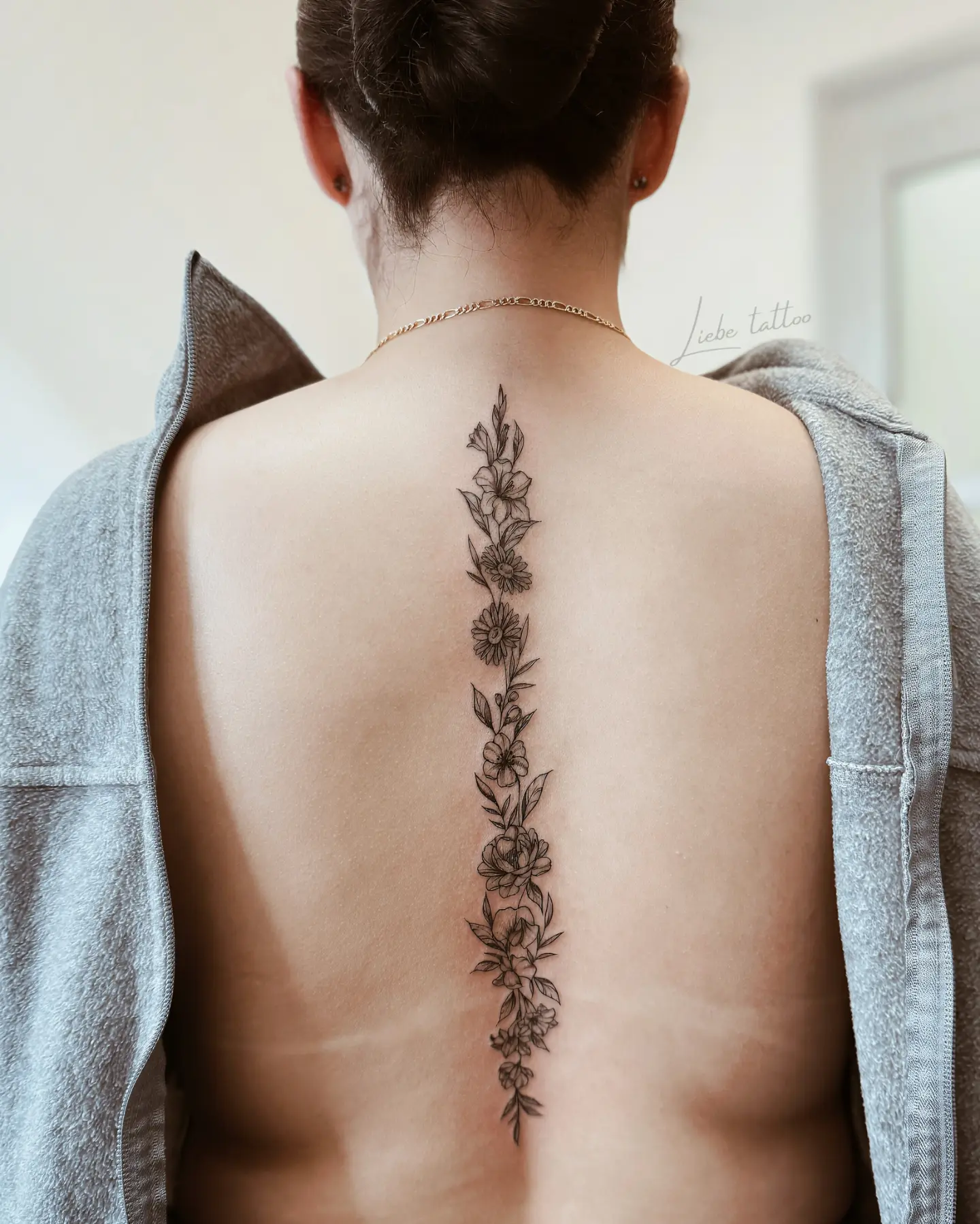 Floral vine black and grey tattoo on the back by Floral Fineline Tattoo