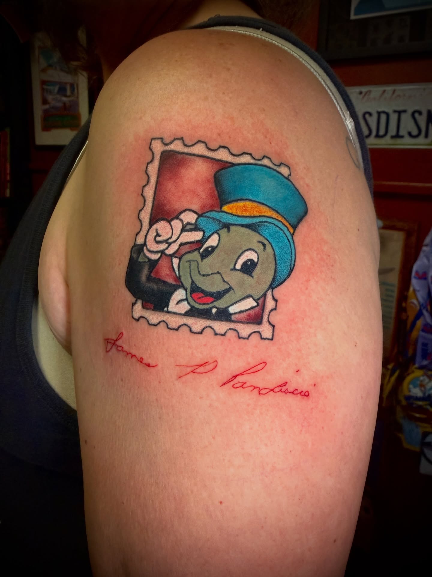 Postage stamp with character illustrative tattoo on the upper arm by 🗿🌴TᗩᕼITI GIᒪ✨🏰