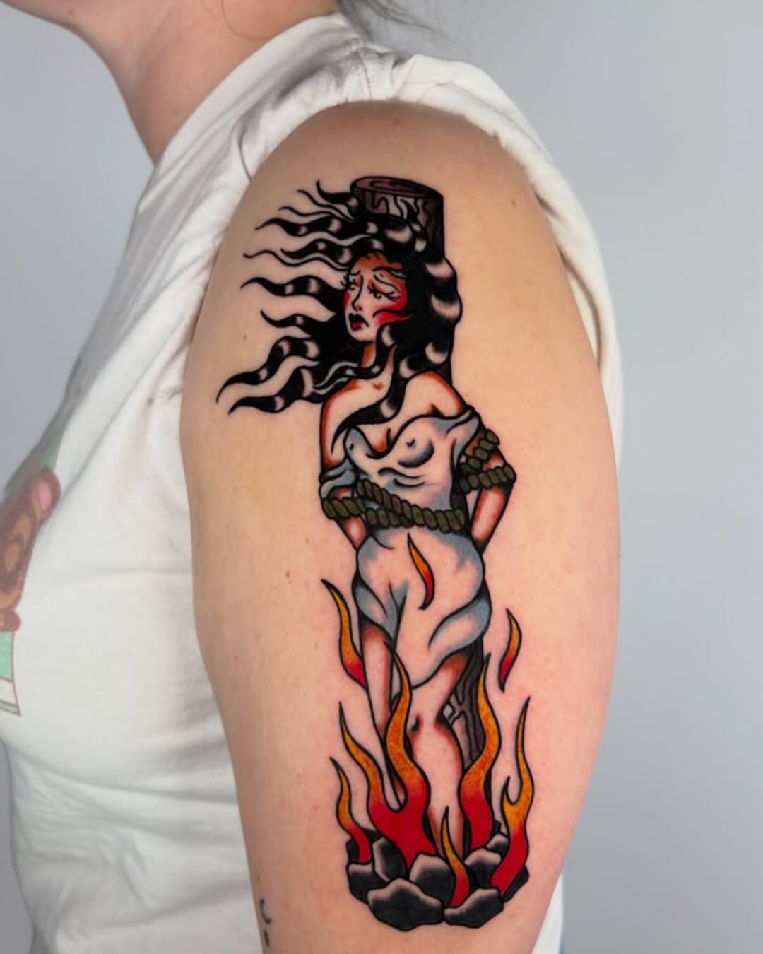 Woman in flames American traditional tattoo on the shoulder by Lorelei