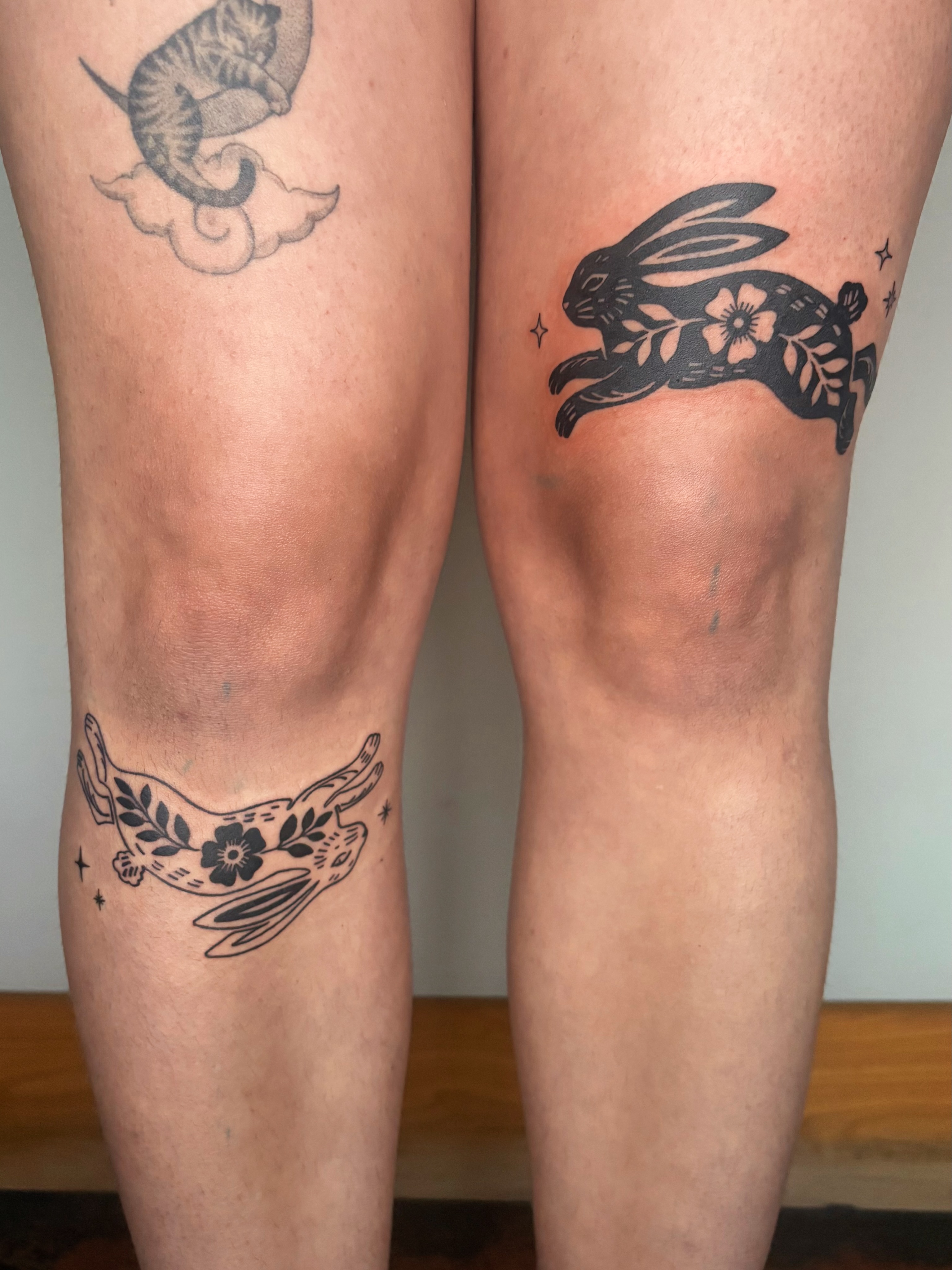 Rabbits and flowers black and grey tattoo on the leg by Abigail, San Francisco, California