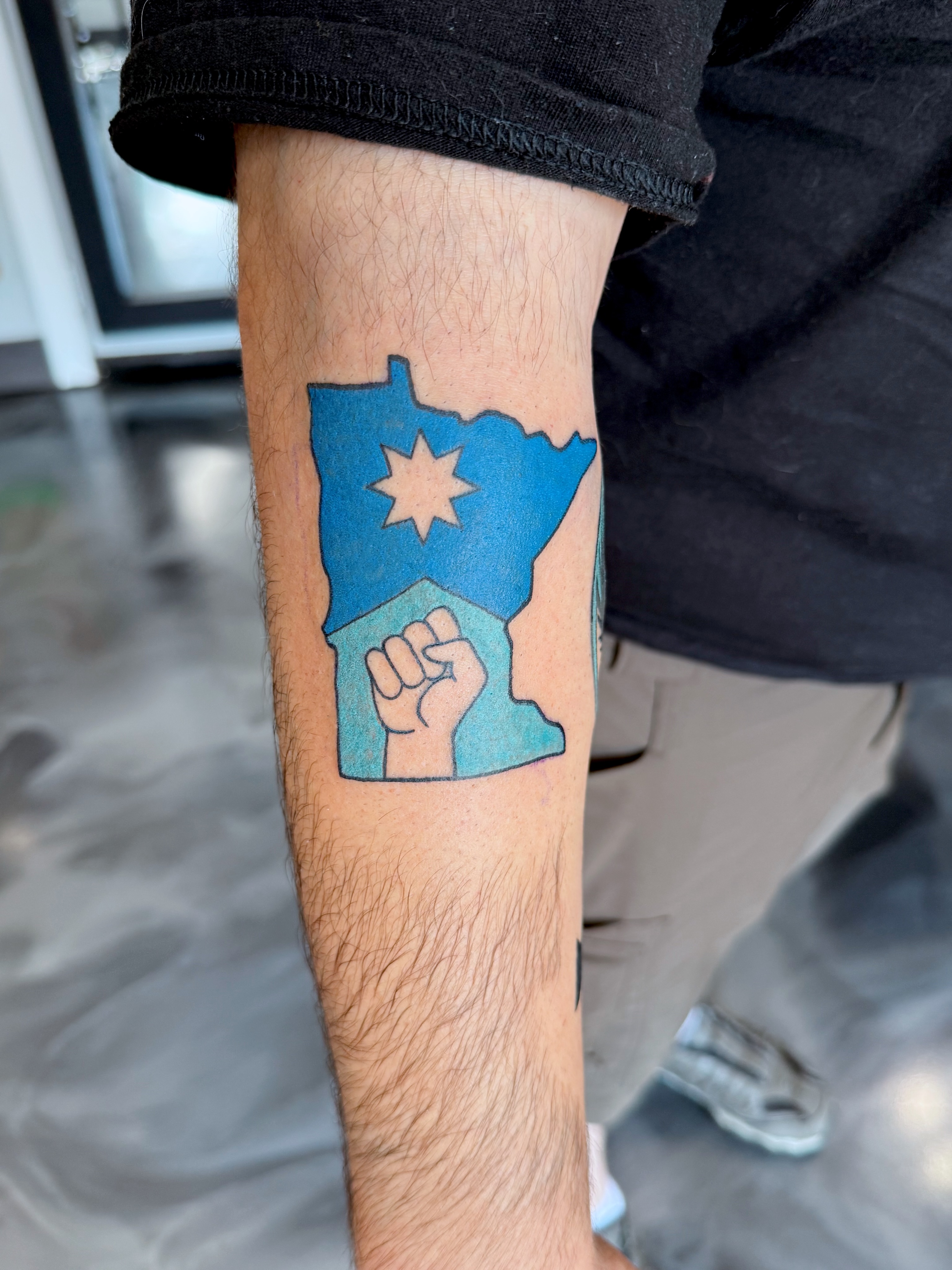 Minnesota state map with fist geometric tattoo on the forearm by Sophie McTear