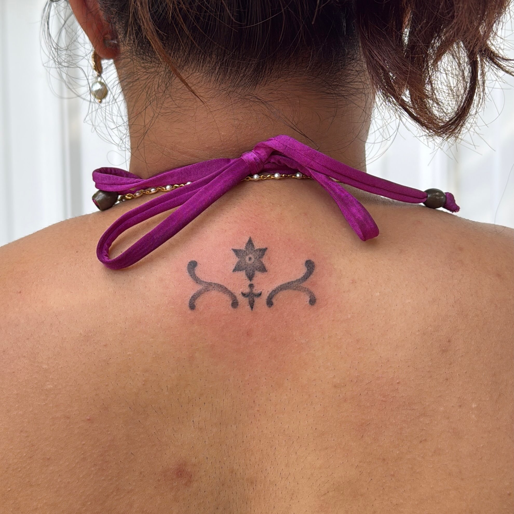 Star with curved lines geometric tattoo on the back by springgreens
