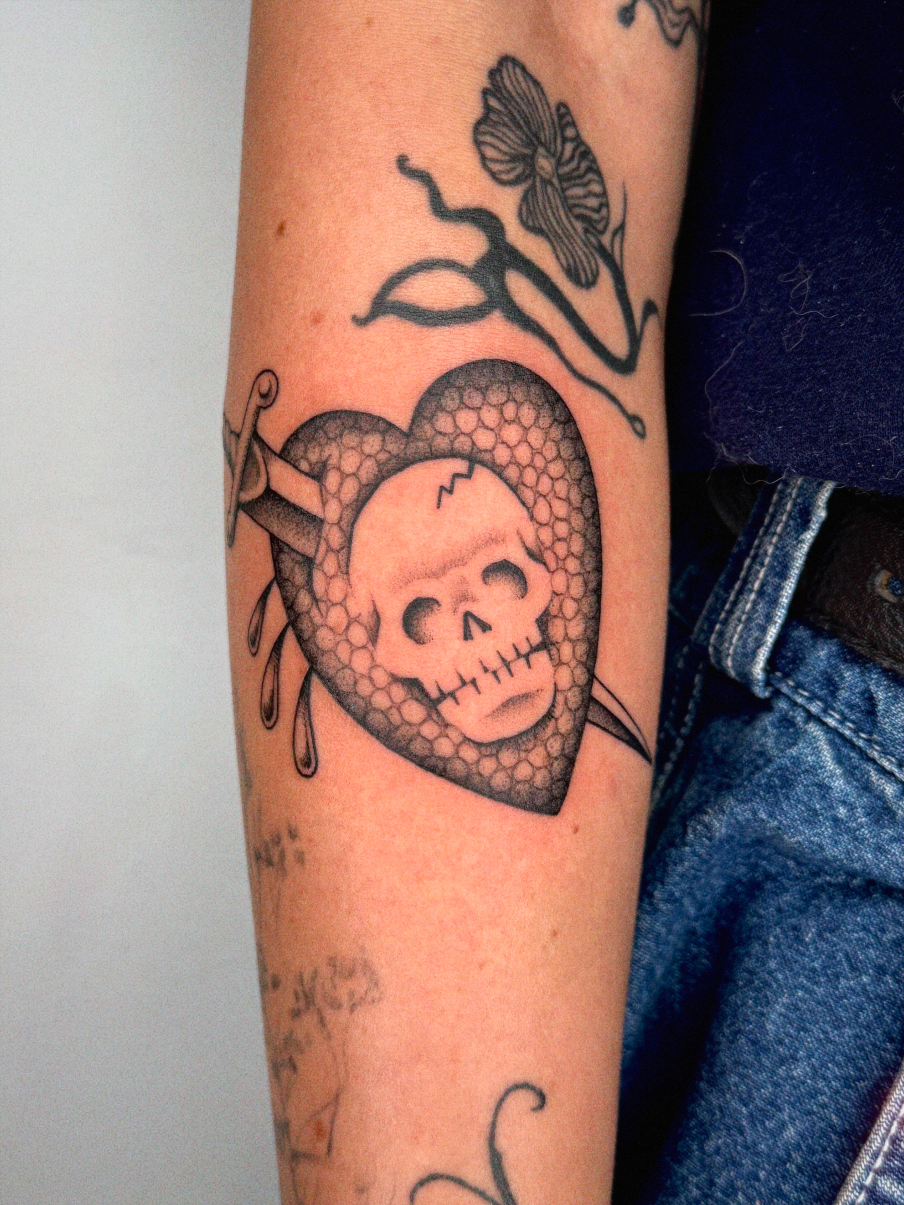 Heart with skull American traditional tattoo on the forearm by @inkshame