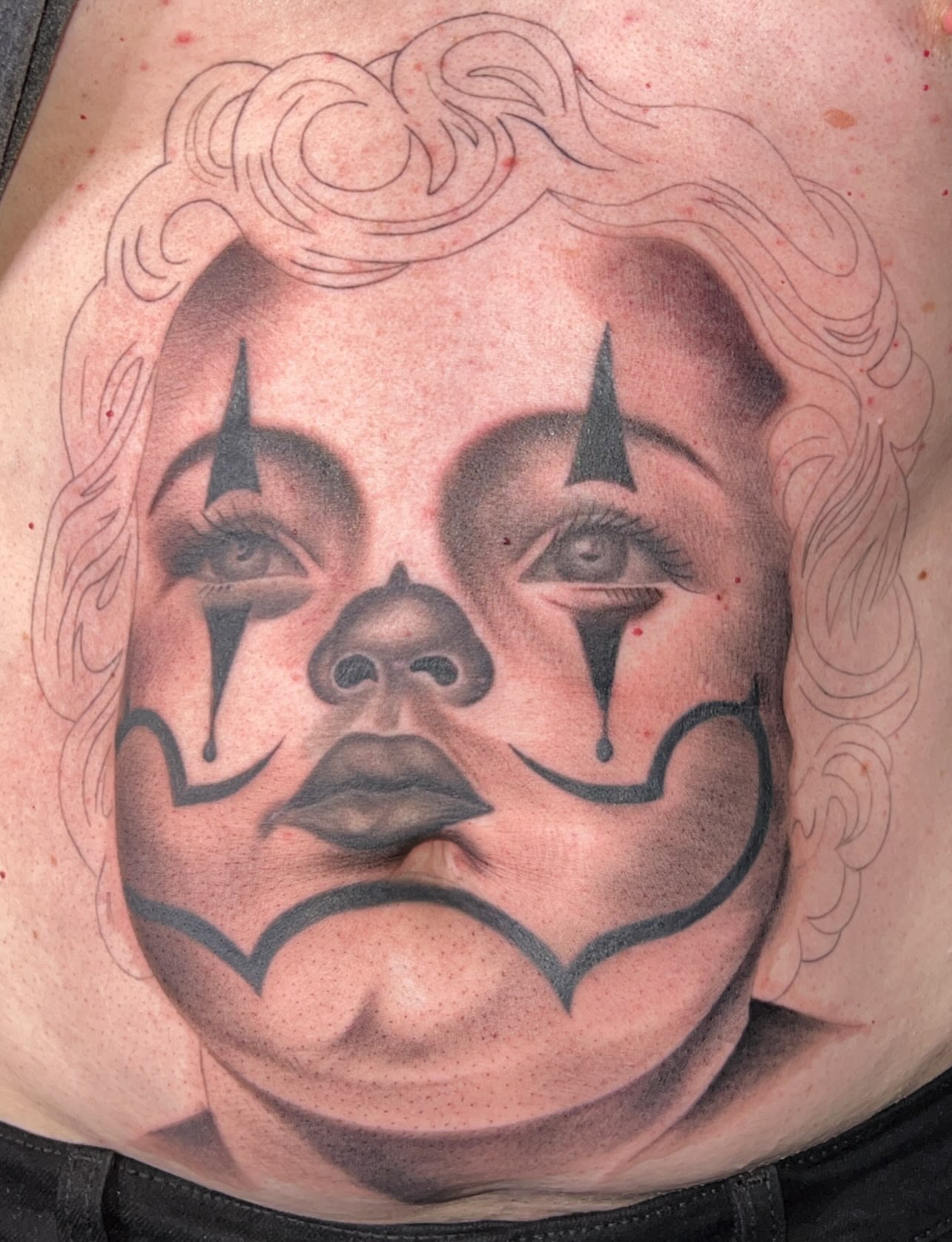Clown face black and grey tattoo on the torso by Dallas tx tattoo artist ✝️