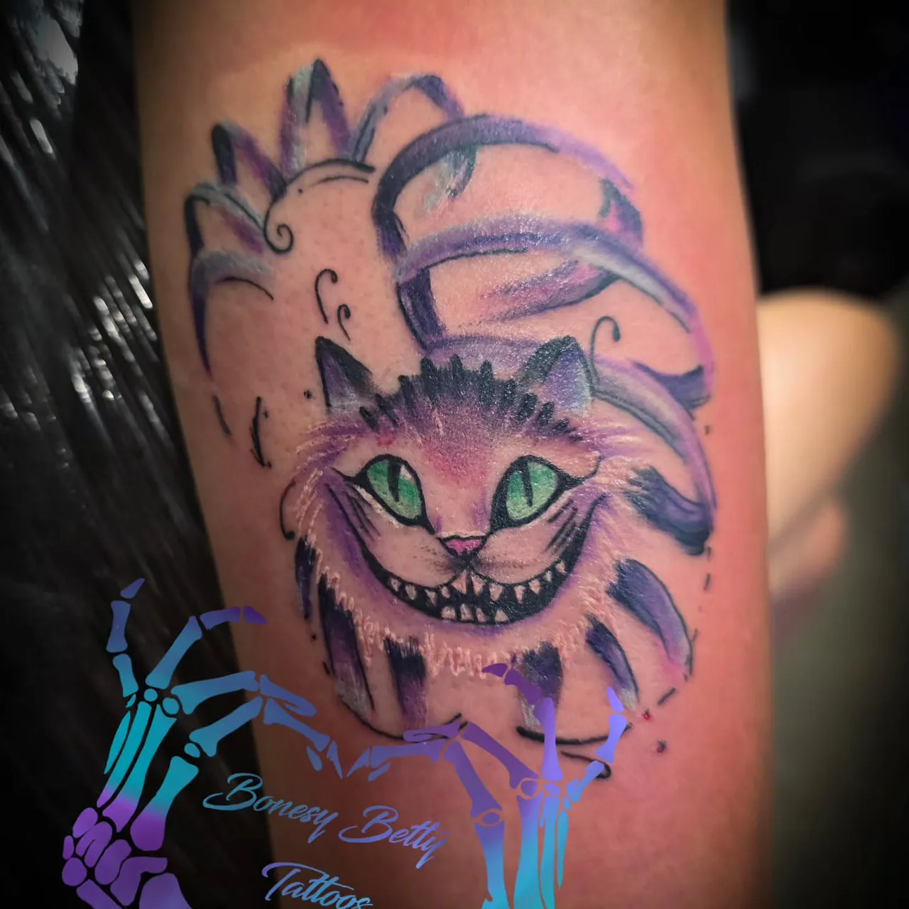 Cheshire cat realism tattoo on the forearm by Betty Browning