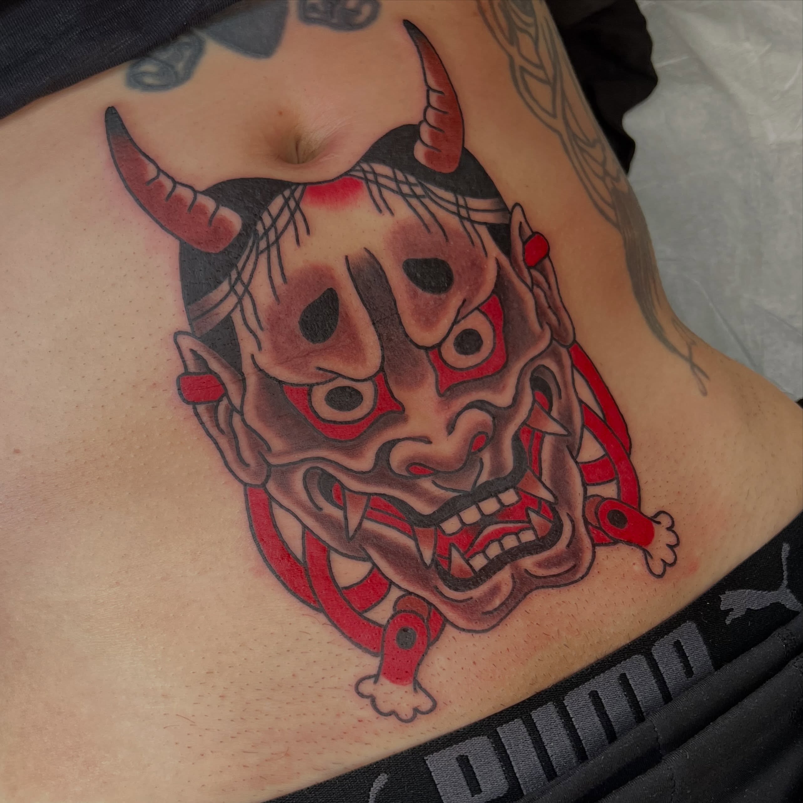 Demon mask japanese irezumi tattoo on the ribs by Mikey Montoya