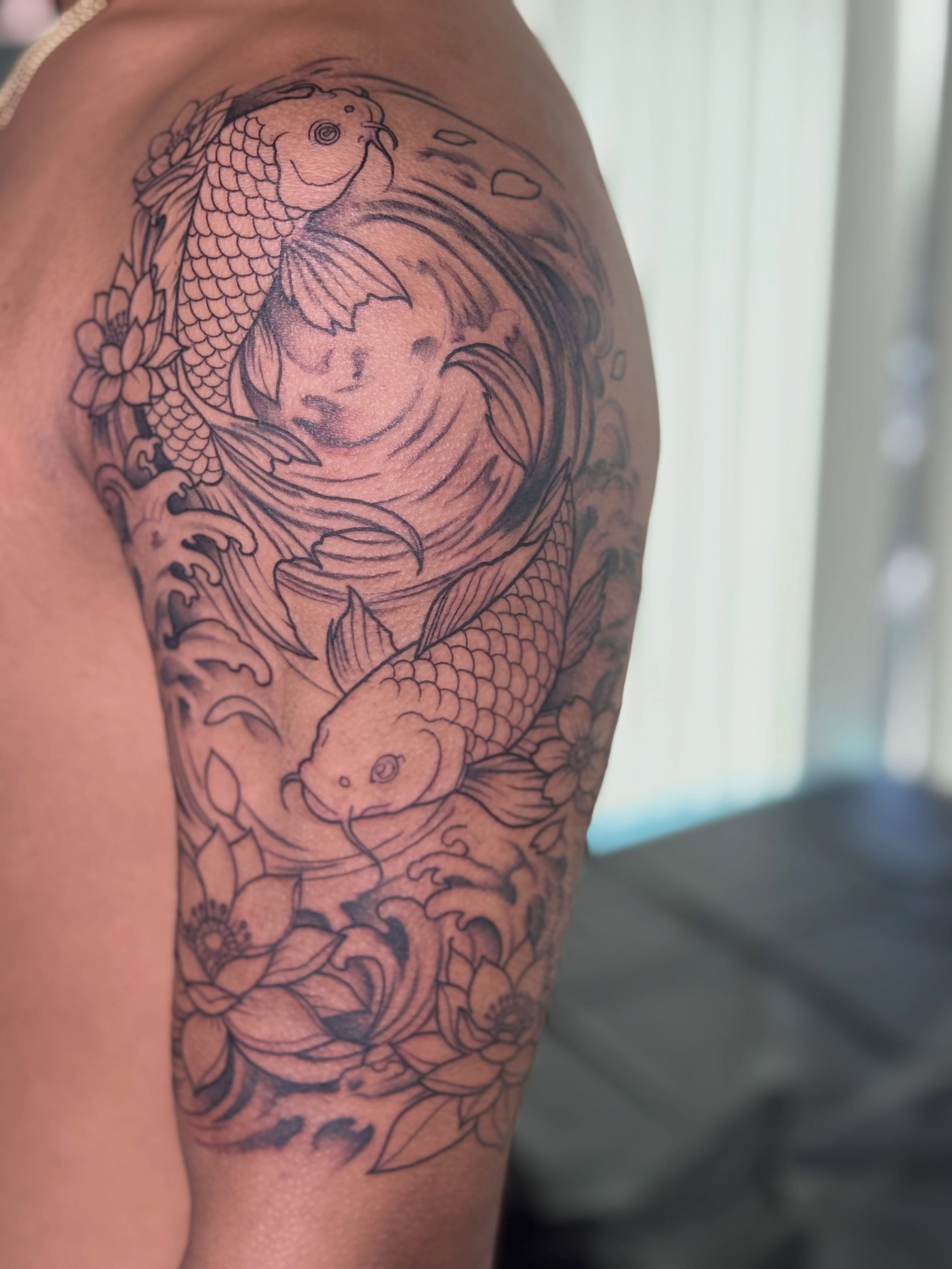 Koi fish and lotus flowers japanese irezumi tattoo on the upper arm by Tattoo, San Diego, California