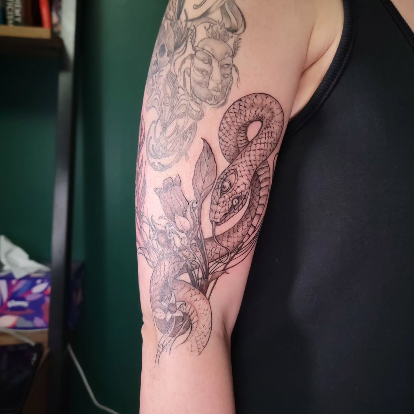 Snake and flowers realism tattoo on the forearm by Nathan Harkins-Oberbeck