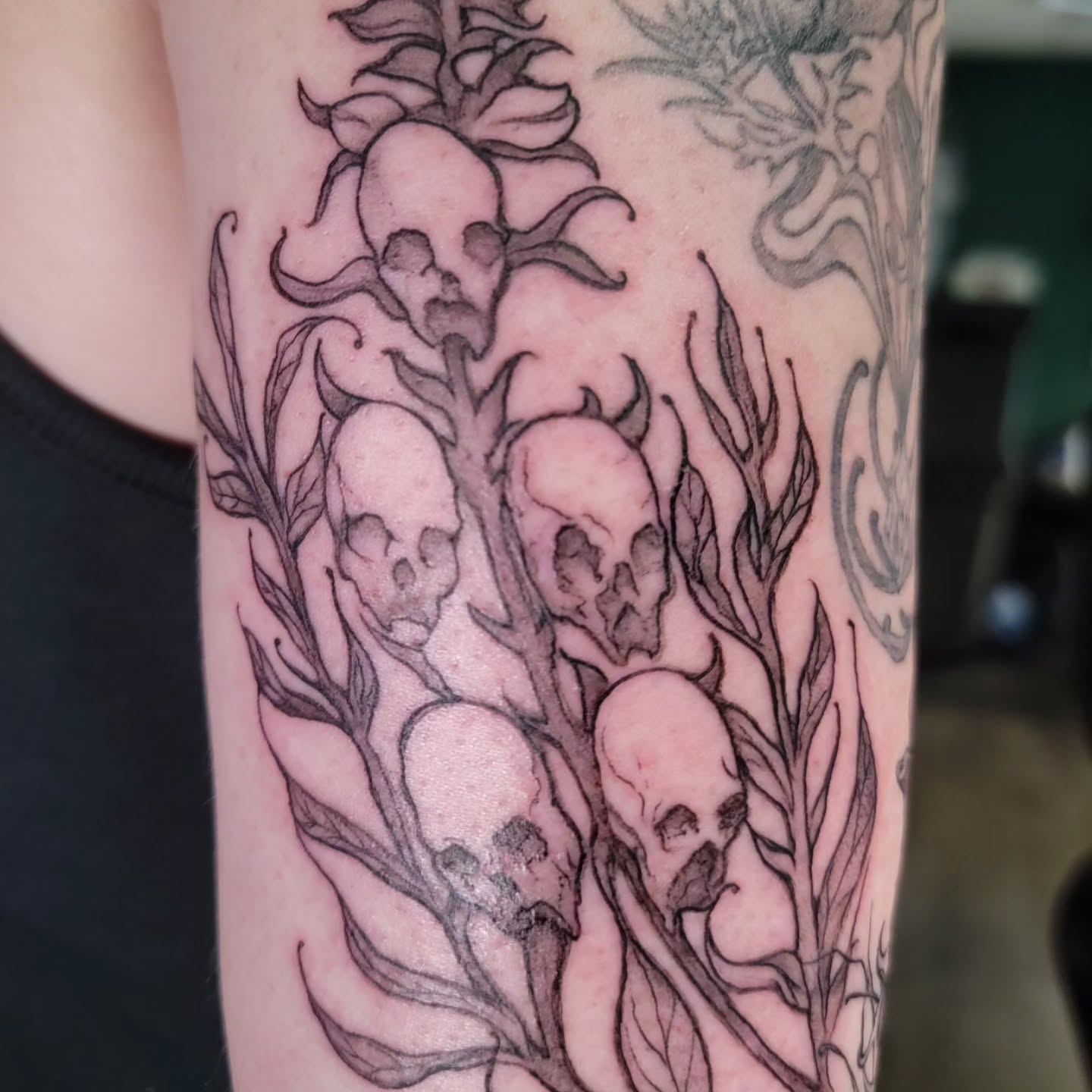 Skulls and leaves black and grey tattoo on the forearm by Nathan Harkins-Oberbeck
