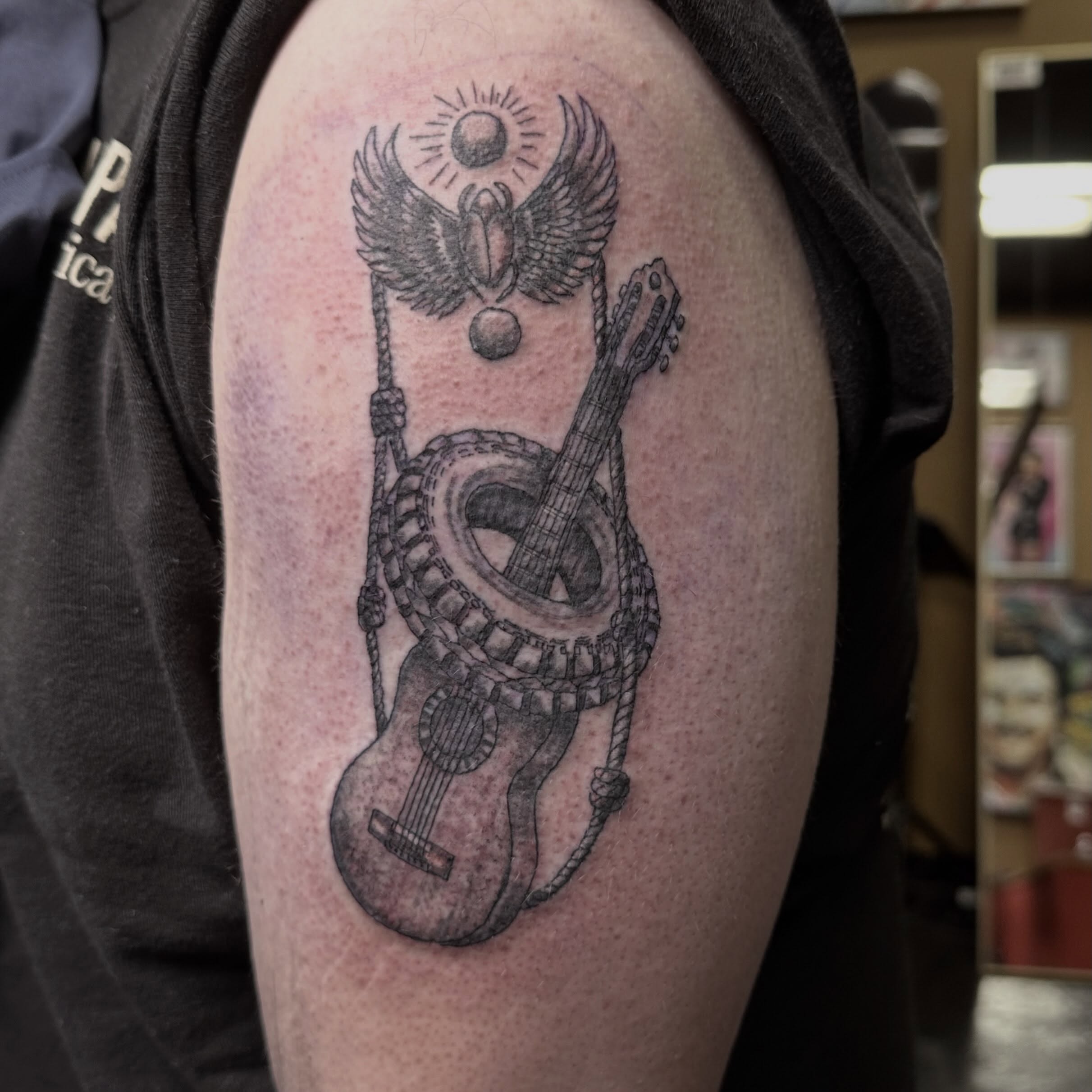 Guitar and eagle realism tattoo on the upper arm by Red (Owner), Brooklyn, New York