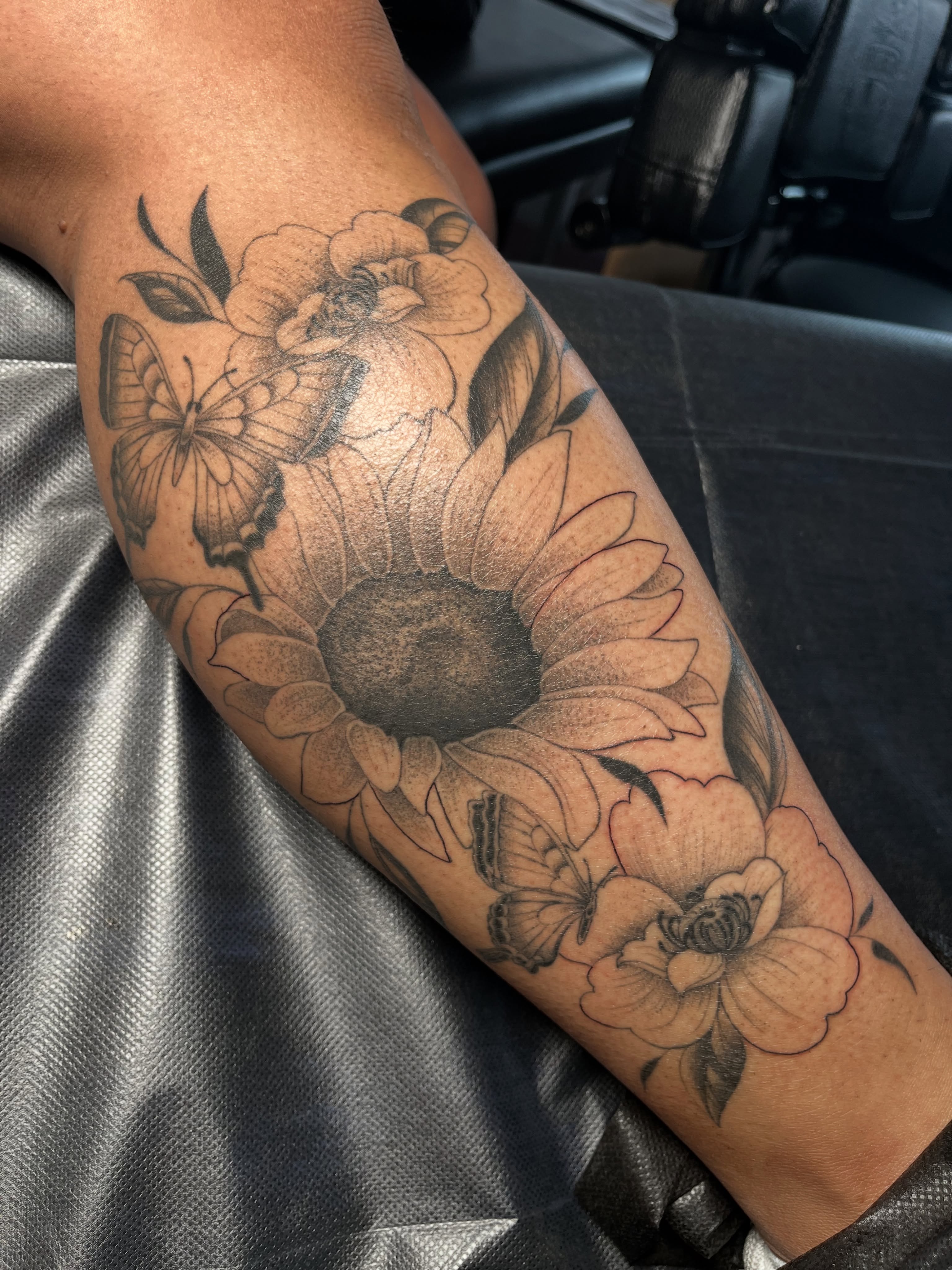 Sunflower and flowers realism tattoo on the forearm by christina diaz