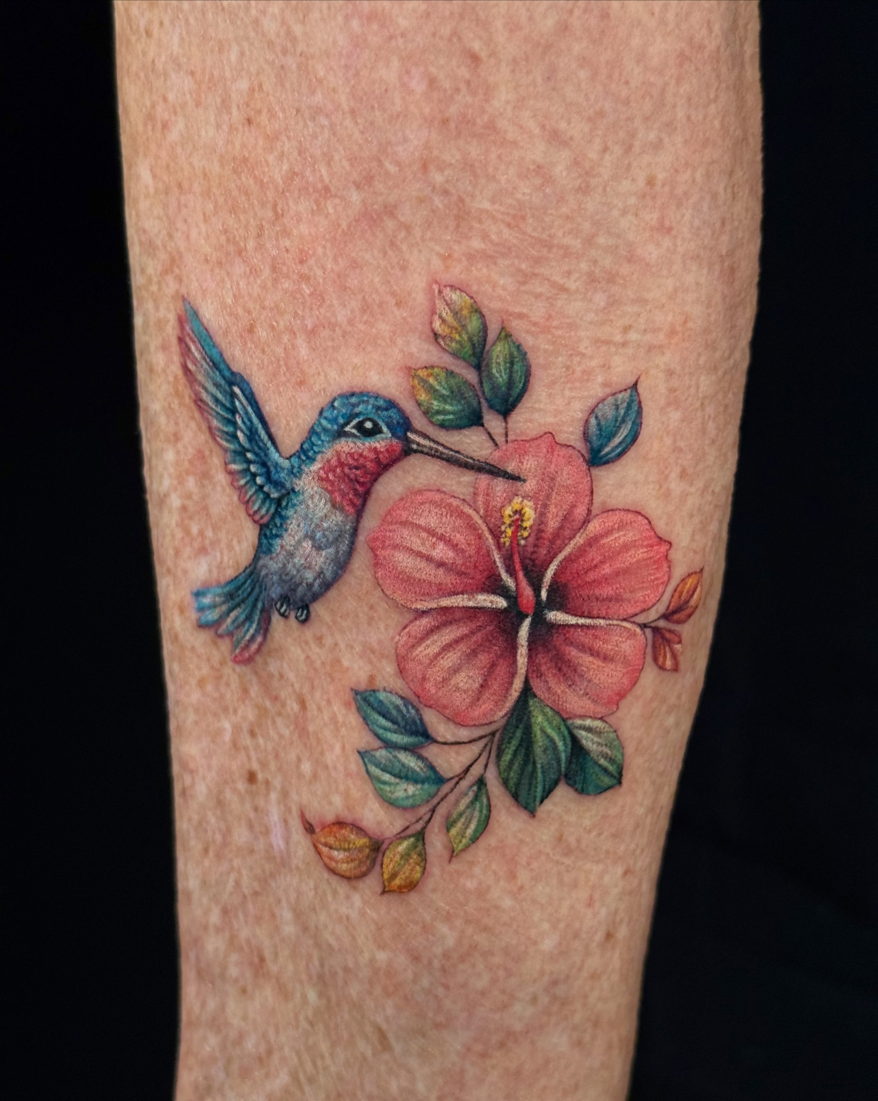 Hummingbird and hibiscus realism tattoo on the forearm by Jade Lewis