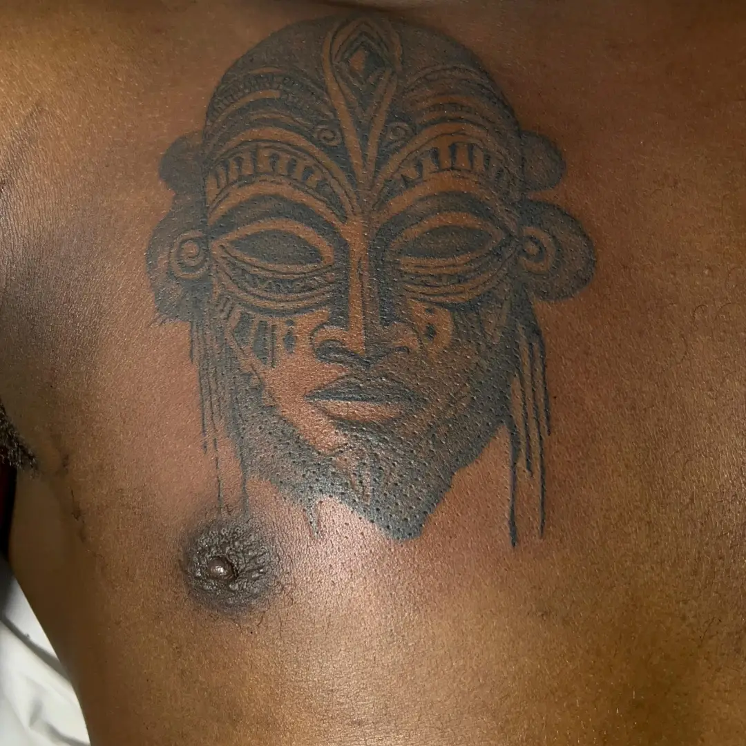Tribal mask tribal tattoo on the shoulder by Mwangaza Bodyworks, Uthiru, Nairobi Area, Kenya