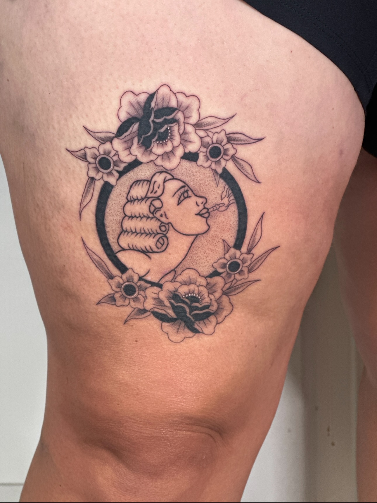 Woman with roses black and grey tattoo on the thigh by Nashville Tattoo Artist - Nicolette Madlyne