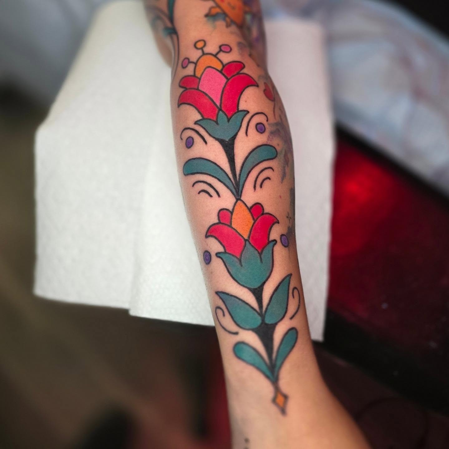 Floral design American traditional tattoo on the forearm by Adison Essig