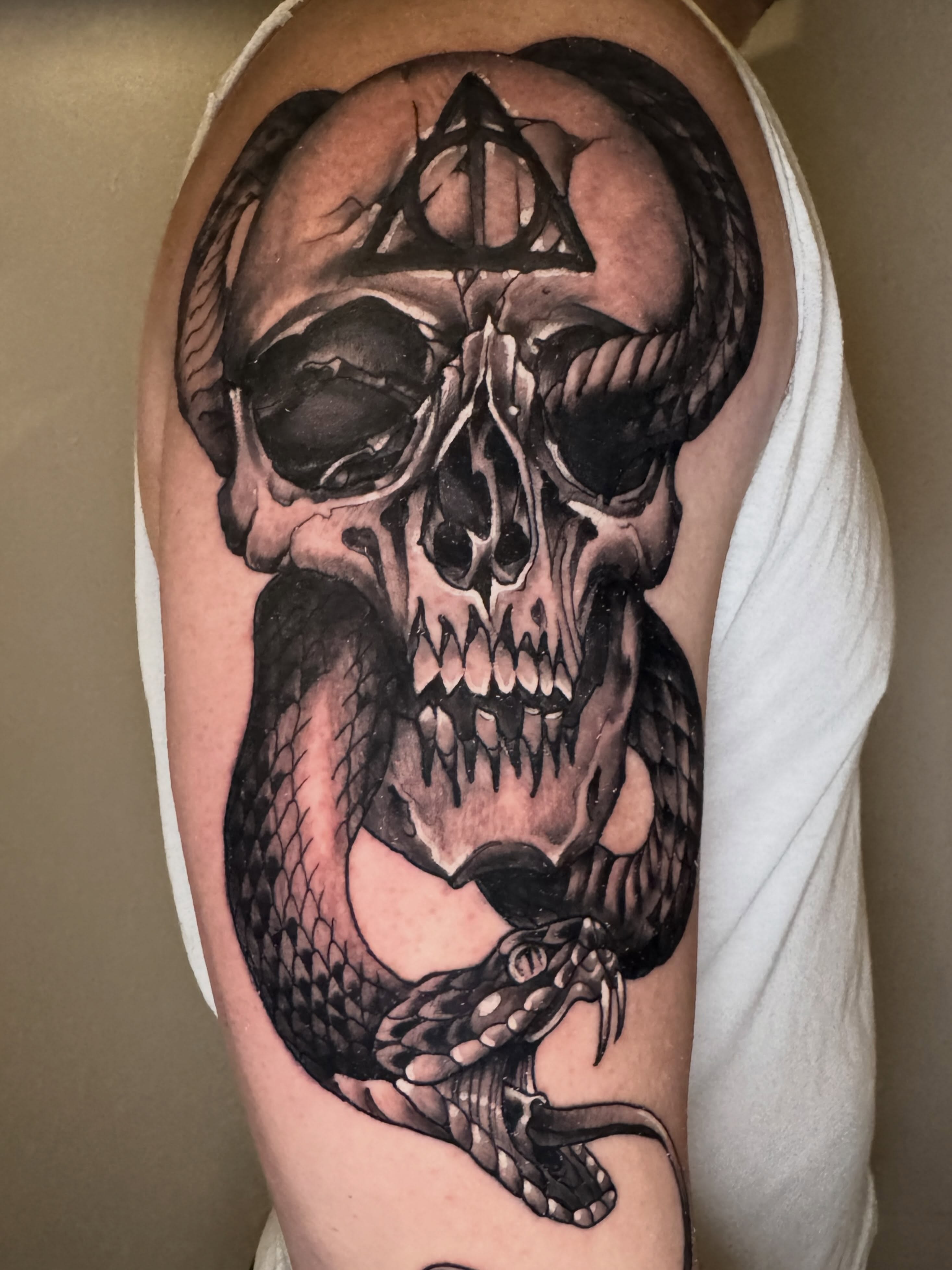 Skull and snake realism tattoo on the upper arm by Mike Bean, Minneapolis, Minnesota