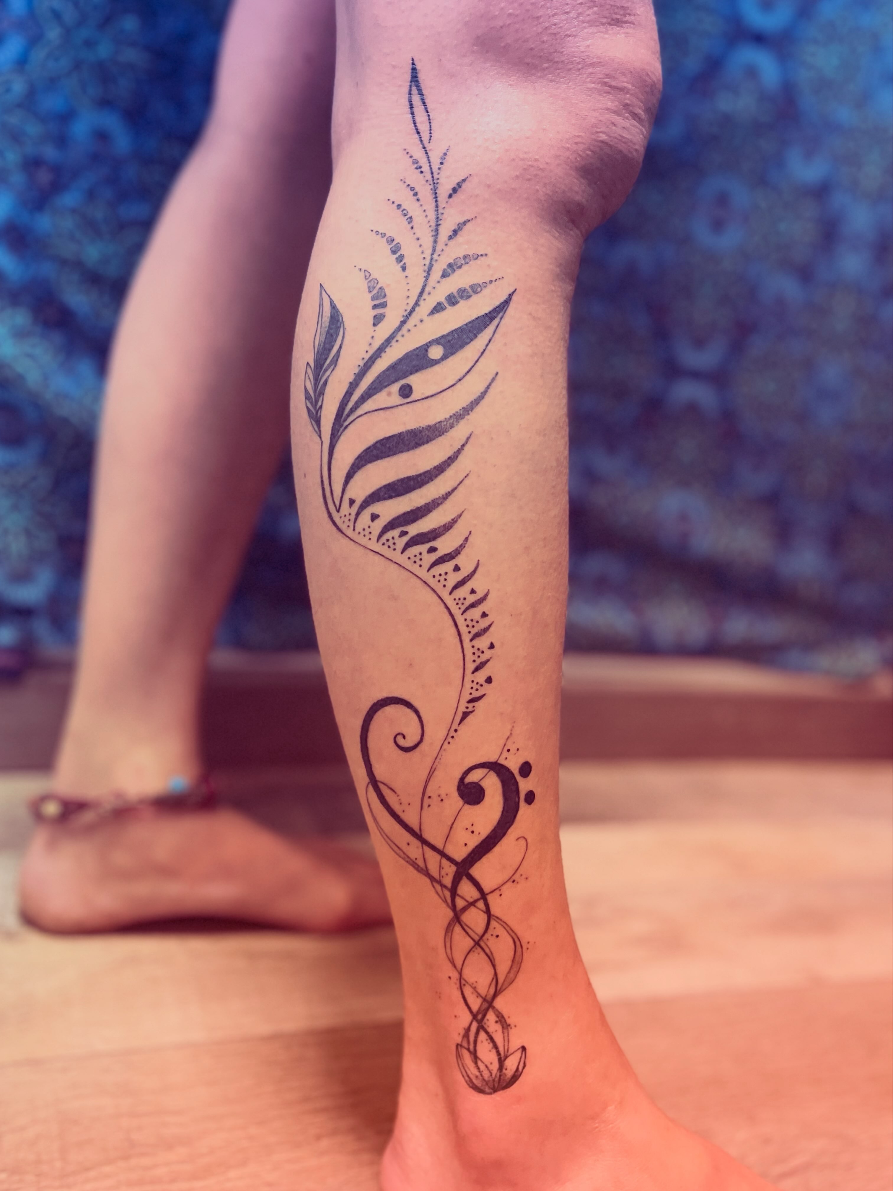 Feather dotwork tattoo on the calf by La Main Bleue
