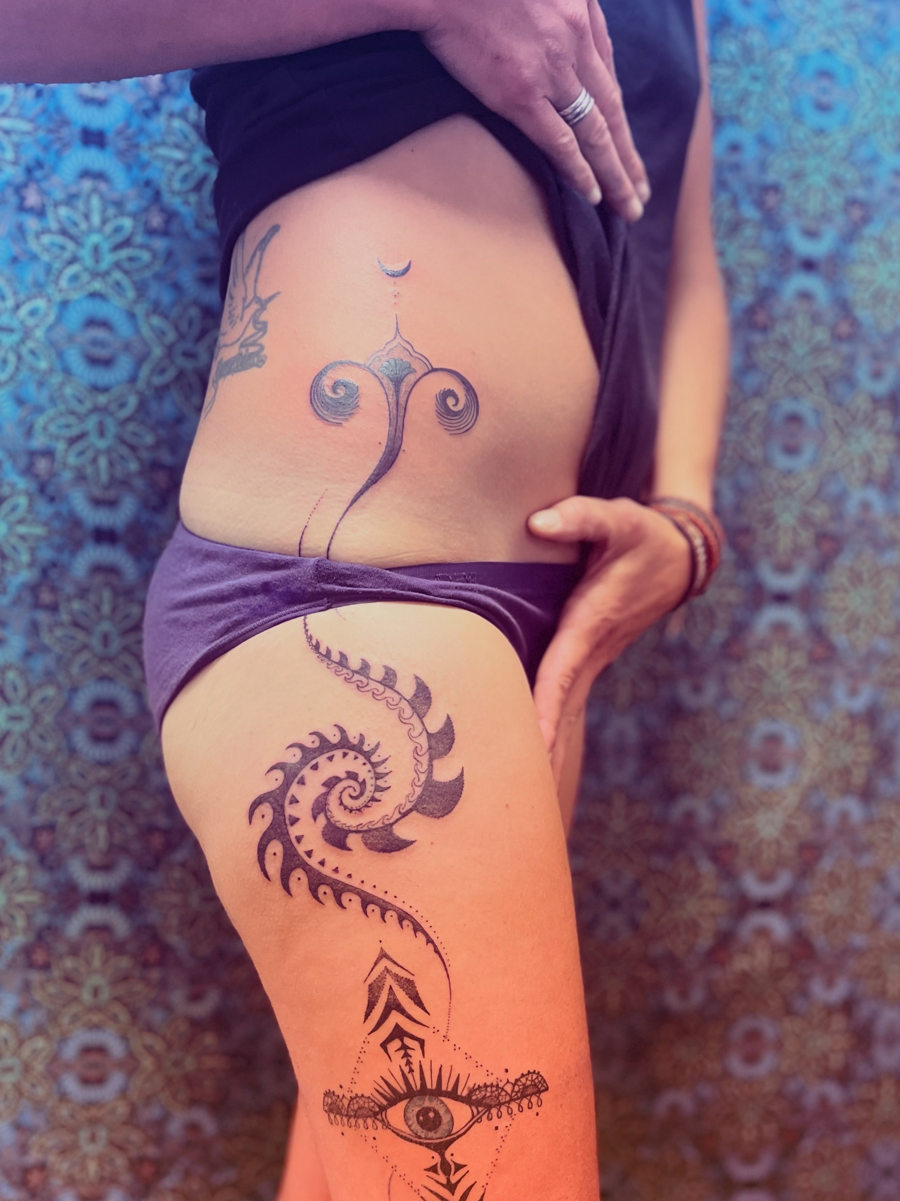 Eye and spiral geometric tattoo on the thigh by La Main Bleue