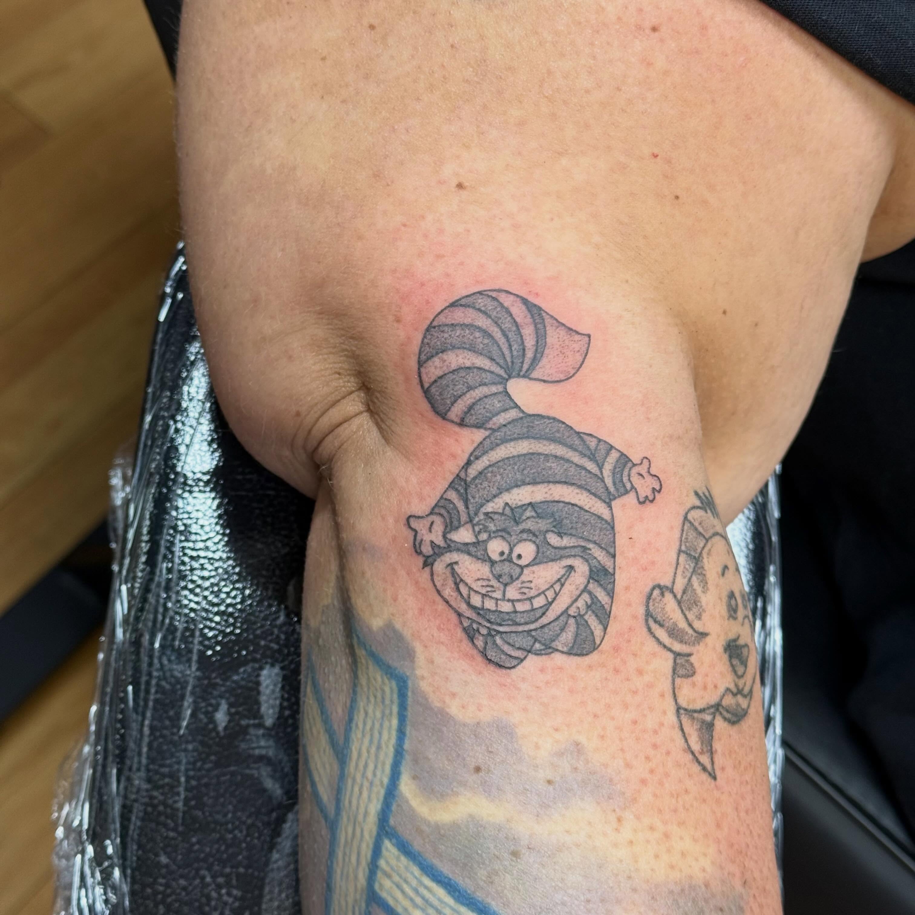 Cheshire cat dotwork tattoo on the forearm by Nic