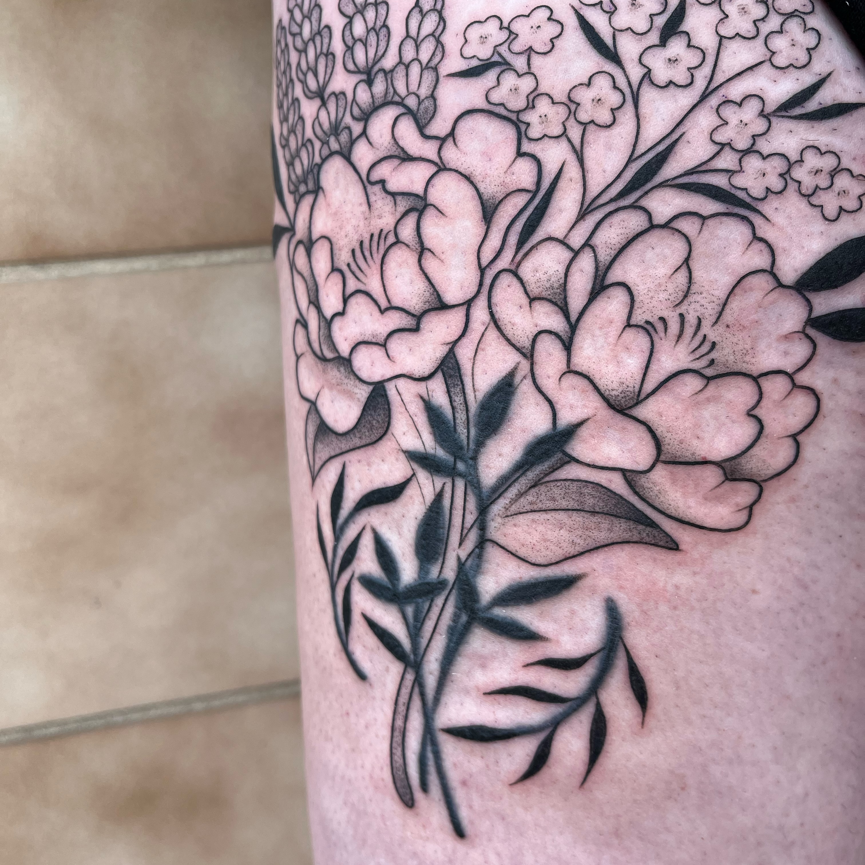 Peony flowers black and grey tattoo on the forearm by Iggy Montgomery (they