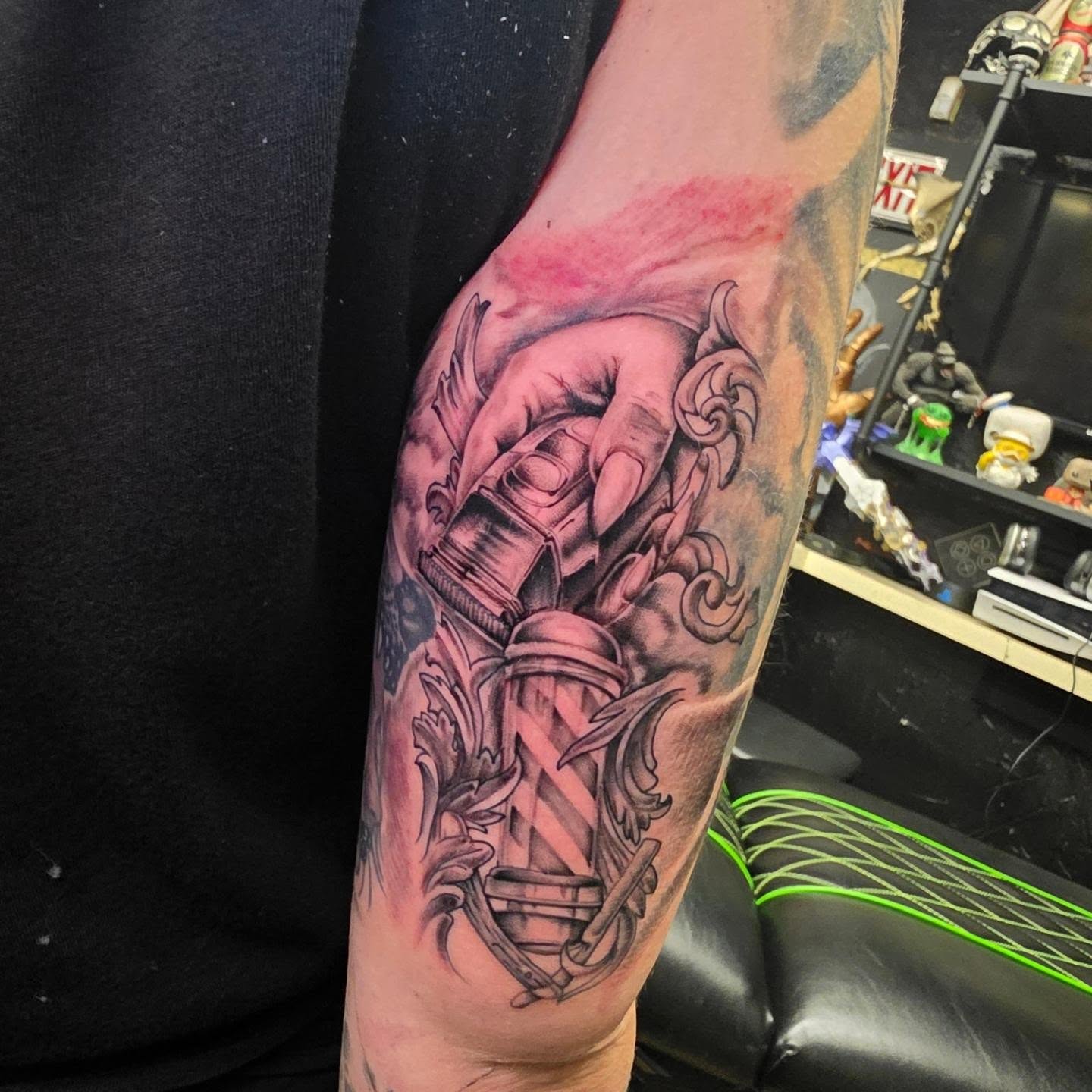 Hand holding bottle realism tattoo on the forearm by komik tattoos