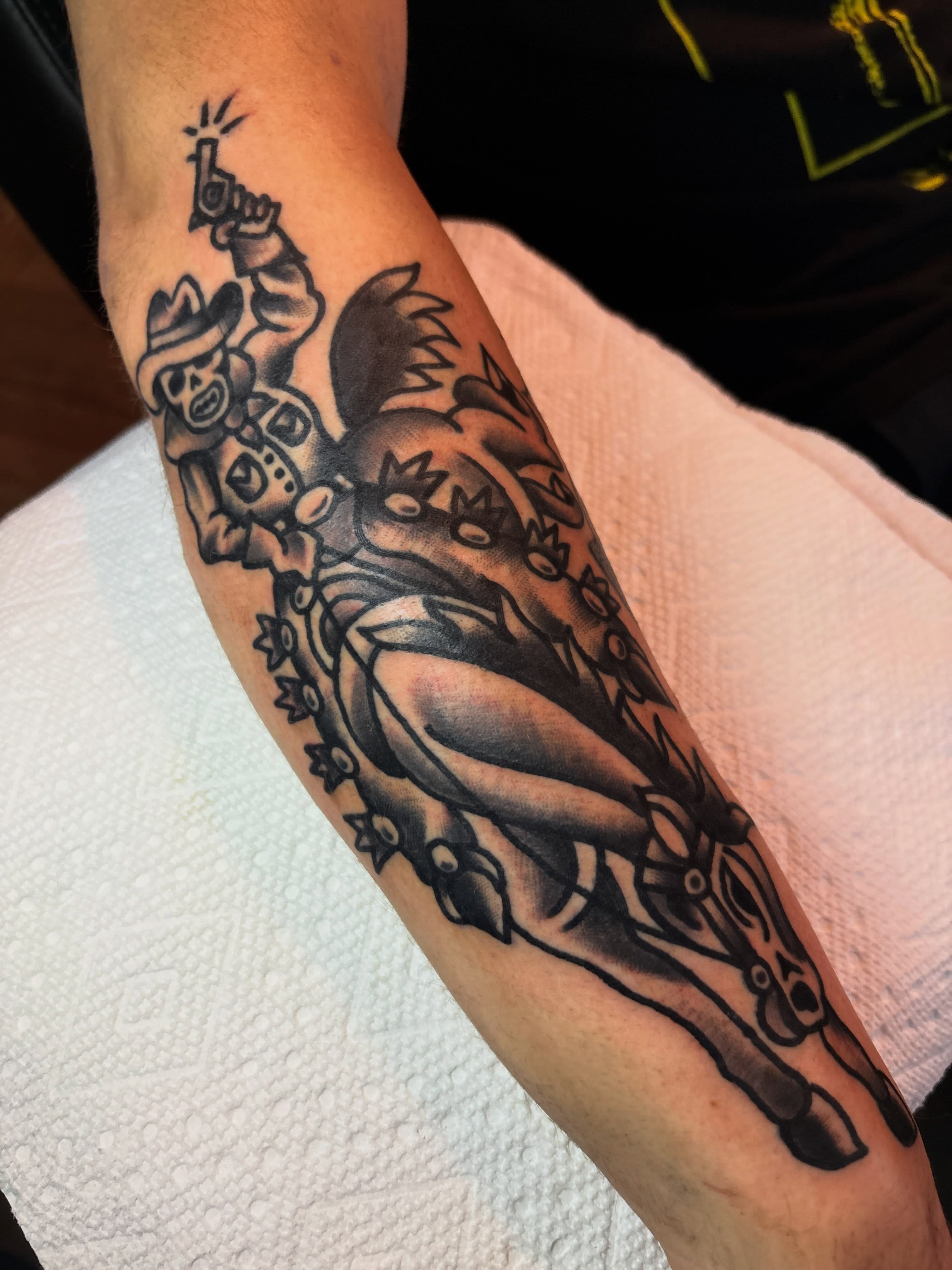 Cowboy on horseback American traditional tattoo on the forearm by Mitch Ashpaugh
