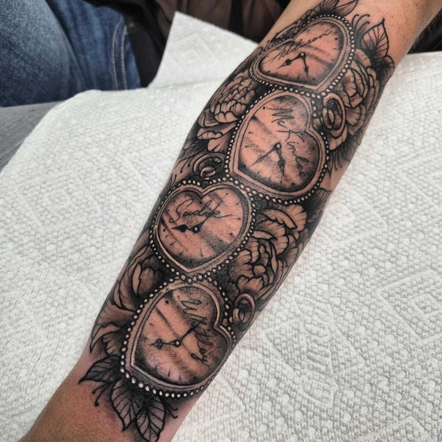 Clocks black and grey tattoo on the forearm by Taylor Popkins
