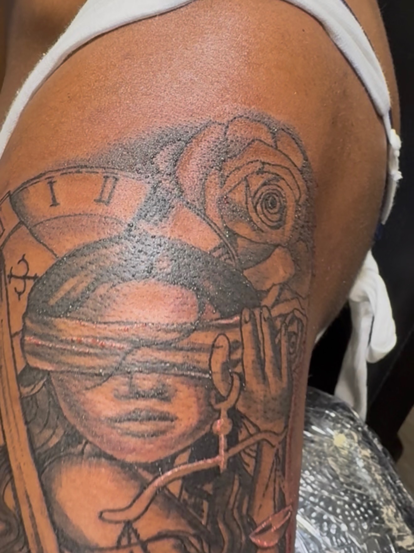 Blindfolded woman with rose dotwork tattoo on the shoulder by Shine Jefferson, Memphis, Tennessee
