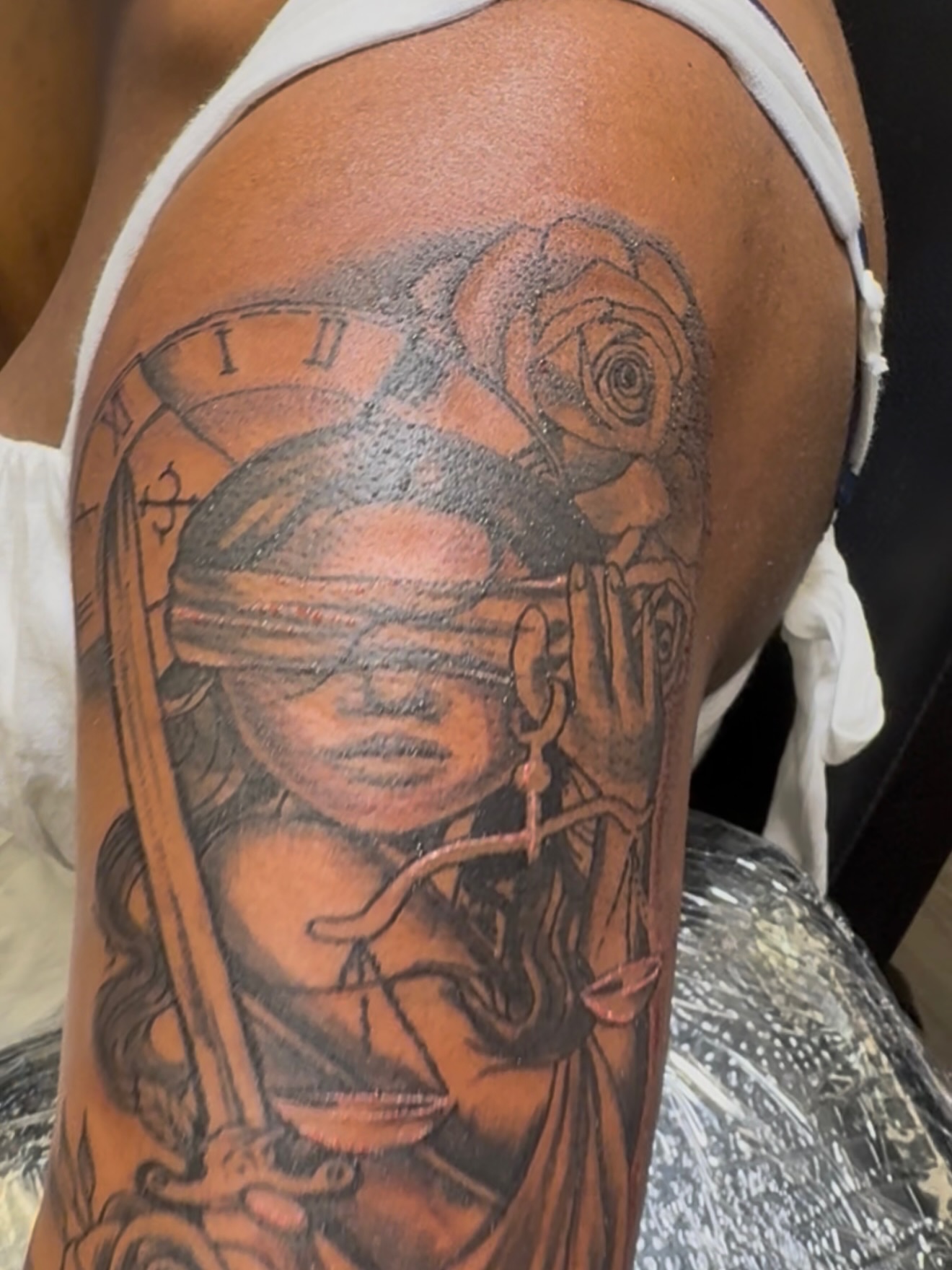 Blindfolded woman with roses realism tattoo on the upper arm by Shine Jefferson, Memphis, Tennessee