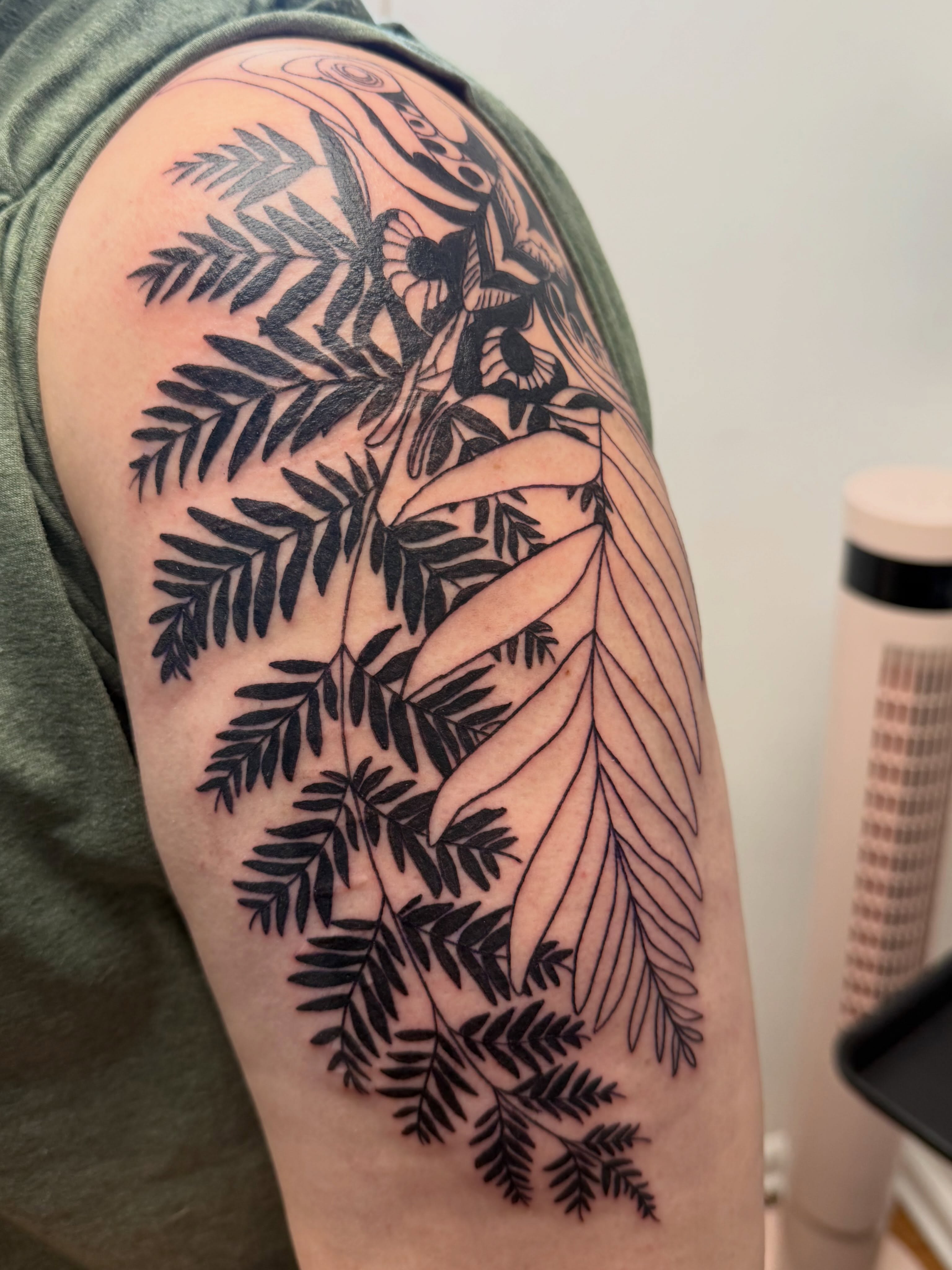 Fern leaves black and grey tattoo on the upper arm by Rebecca (Becca) Ray