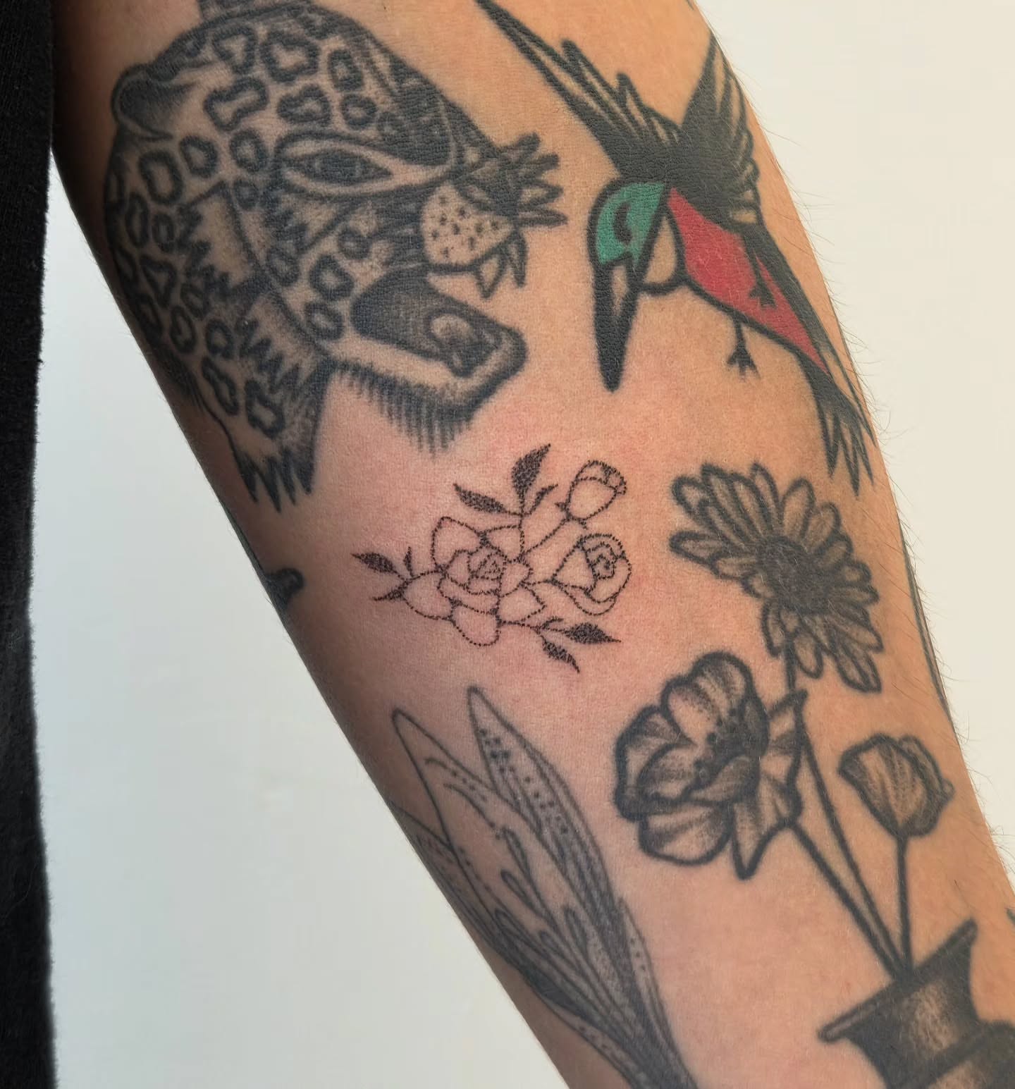 Bird and flowers black and grey tattoo on the forearm by jules tattoos