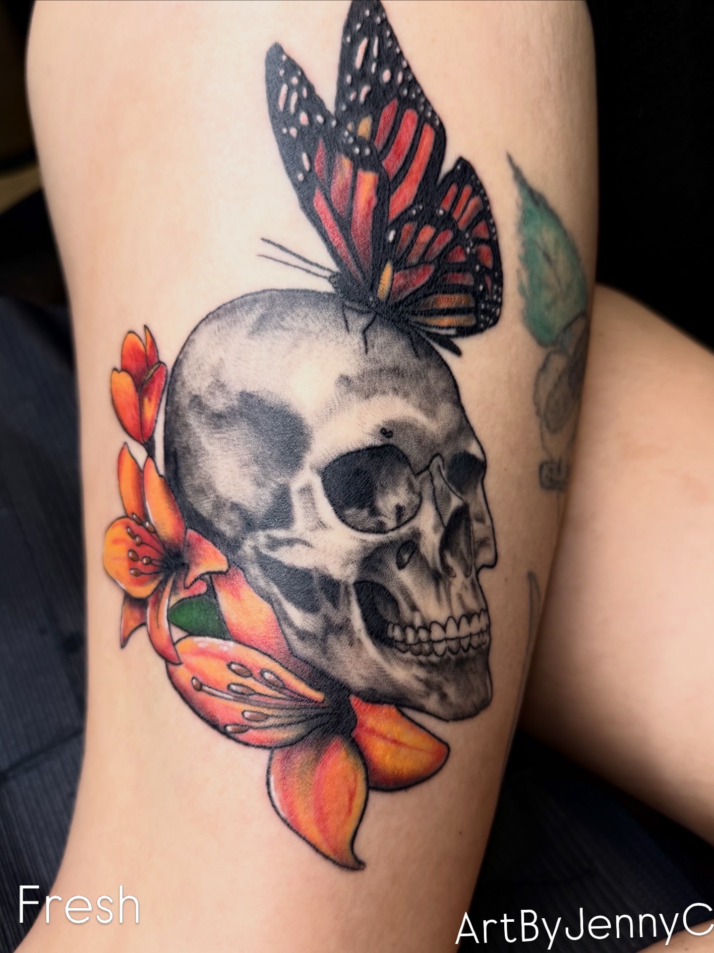 Skull with butterfly and flowers realism tattoo on the forearm by Jennifer Contreras