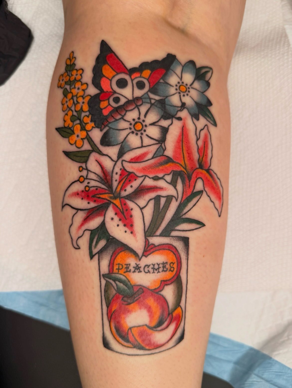 Peaches and flowers American traditional tattoo on the forearm by Emma Fox Tattoo