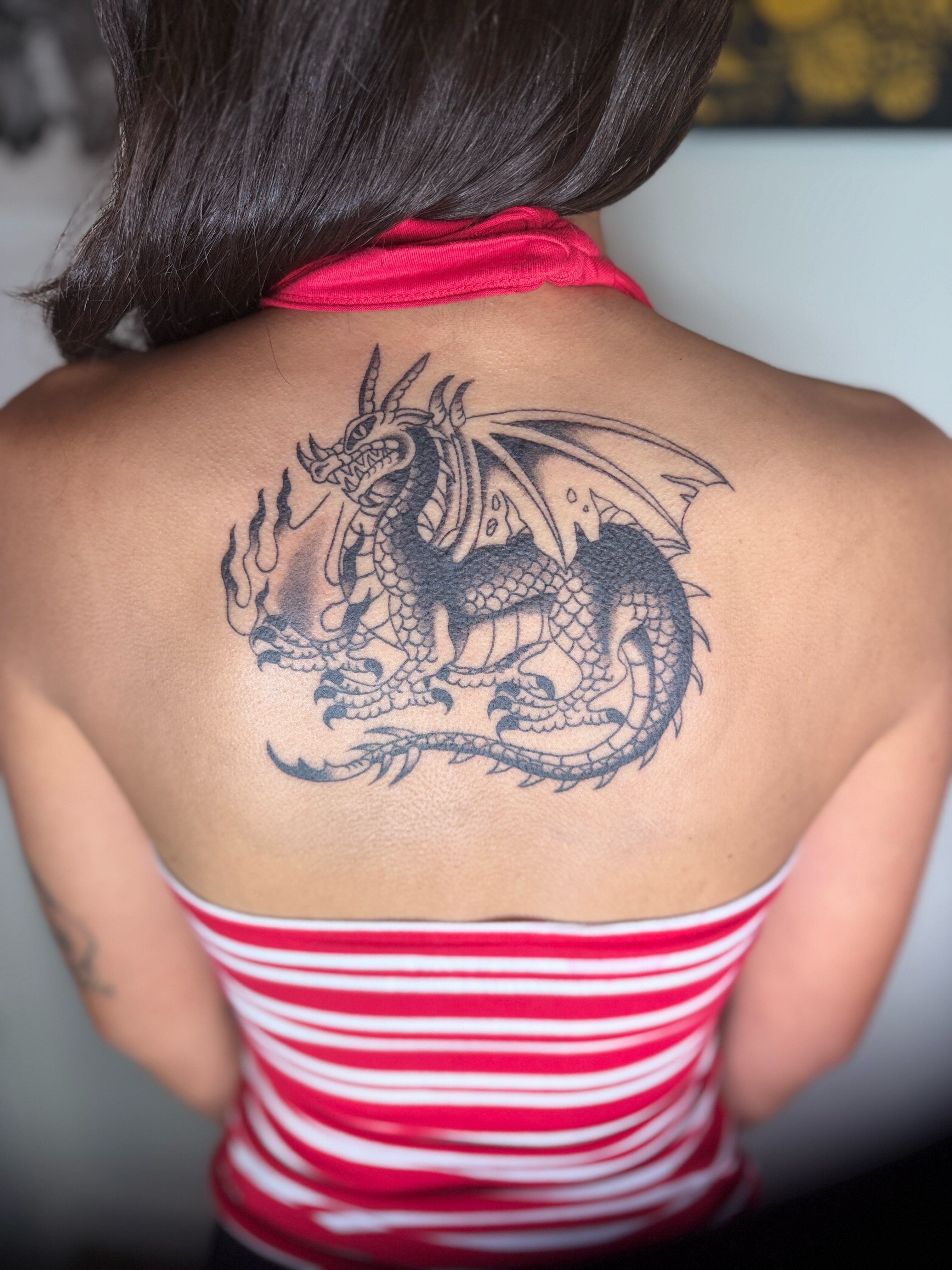 Dragon black and grey tattoo on the back by Emma Fox Tattoo