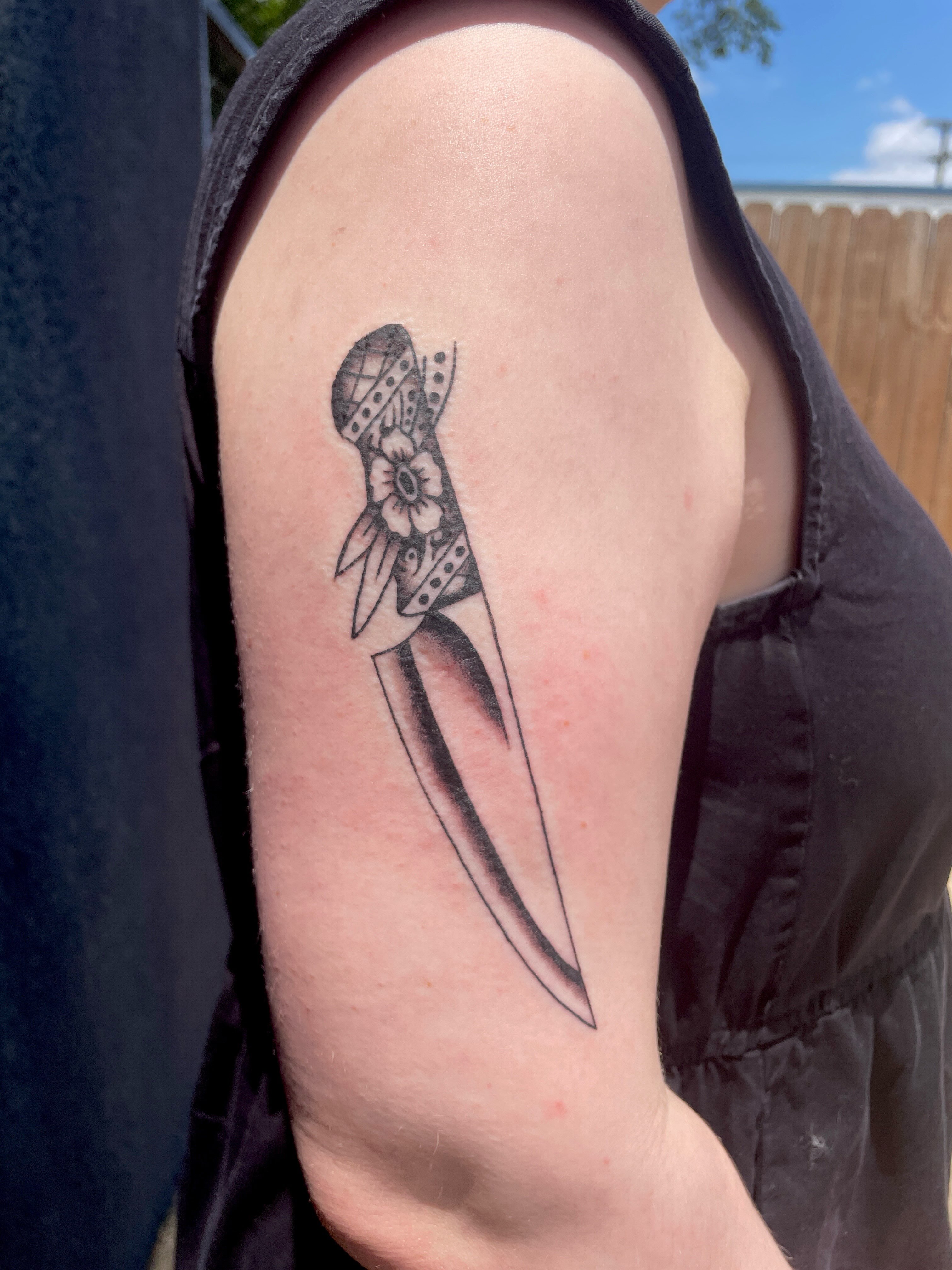 Knife with bandana black and grey tattoo on the forearm by Emma Fox Tattoo