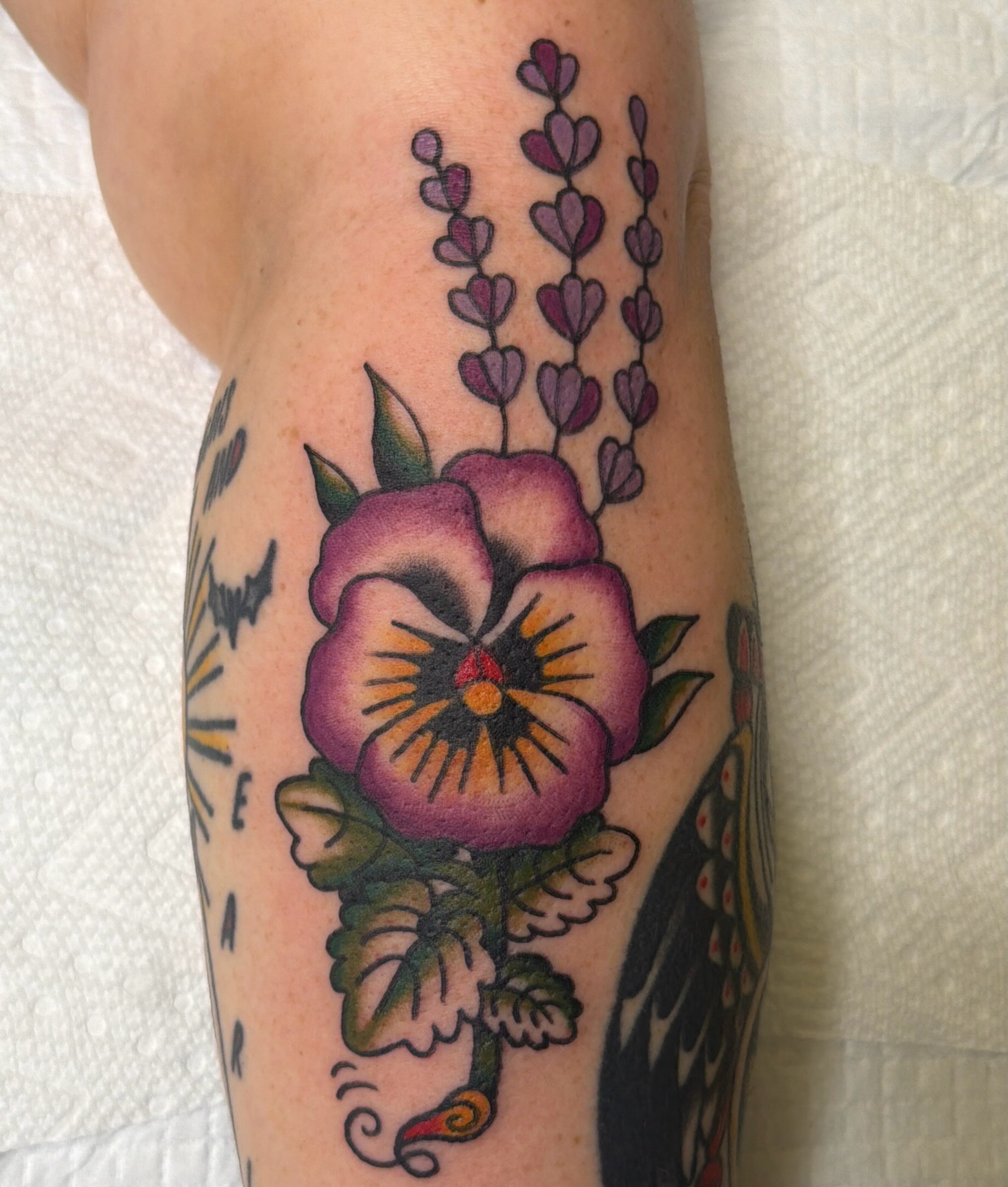 Purple pansy American traditional tattoo on the forearm by Emma Fox Tattoo