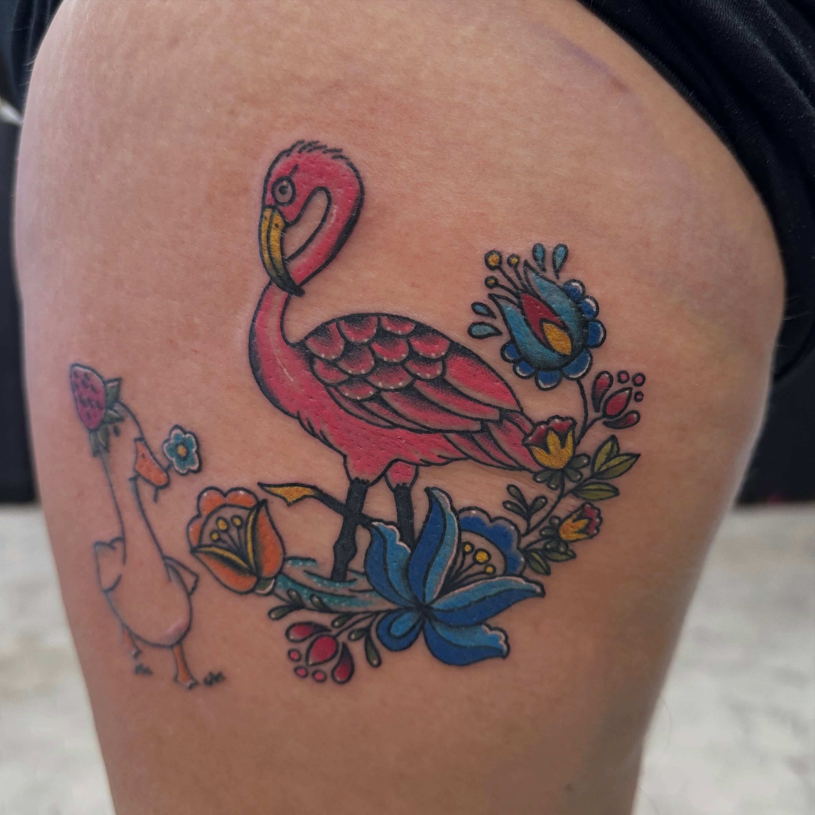 Flamingo and flowers American traditional tattoo on the thigh by Nicki Hoverson