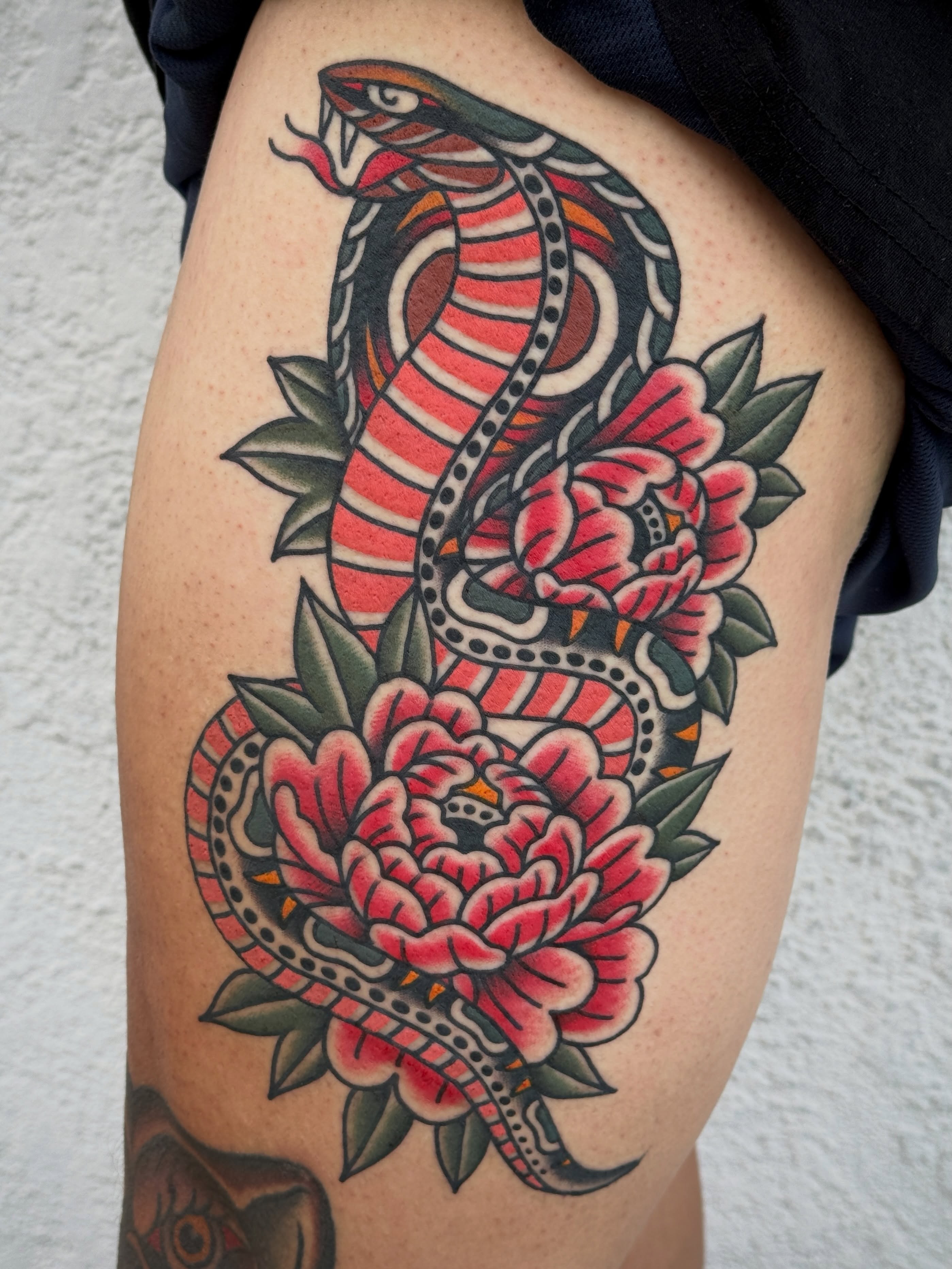 Snake and peony American traditional tattoo on the thigh by Jordan Allen