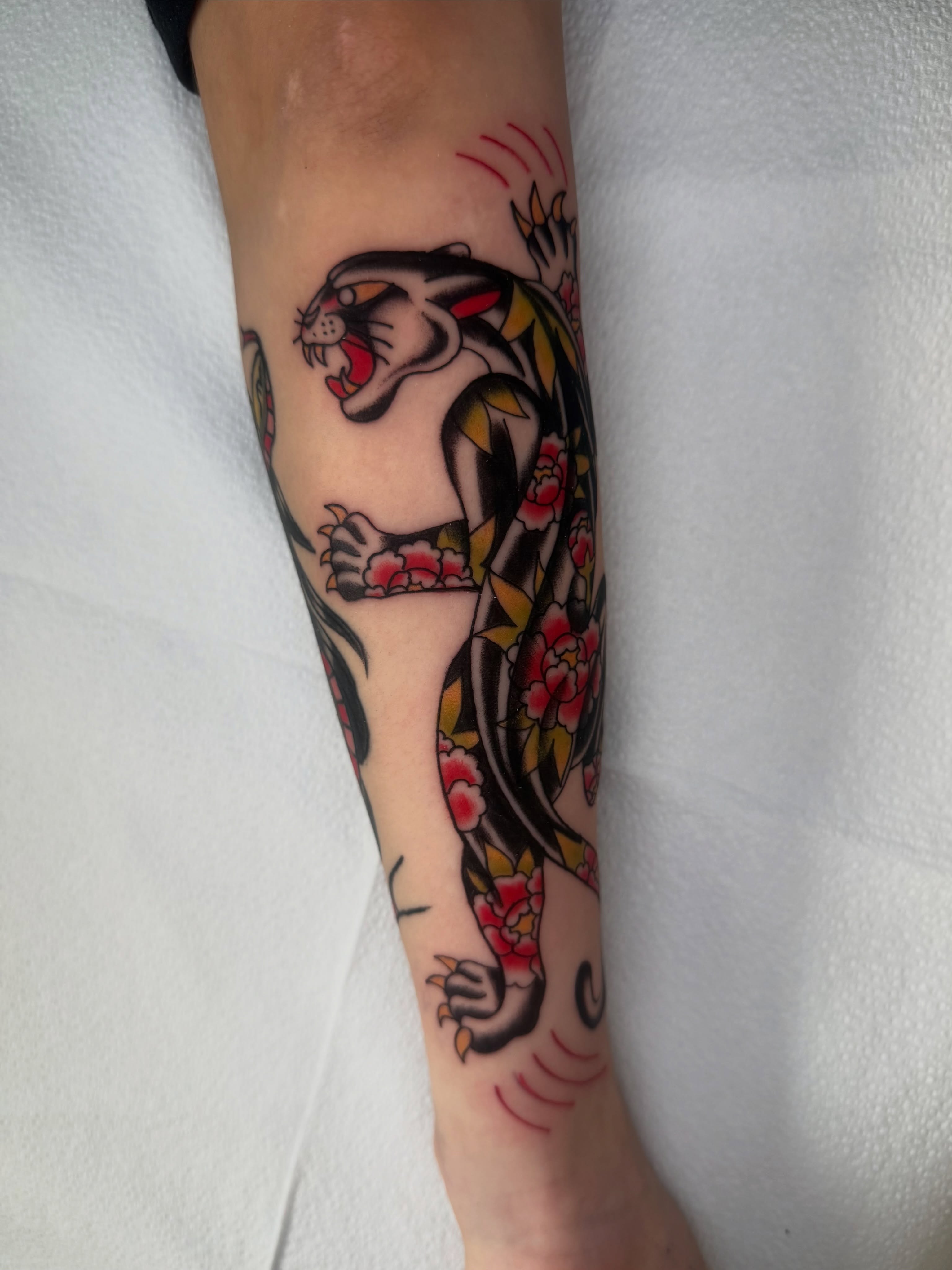 Dragon and flowers American traditional tattoo on the forearm by Lexie Graff