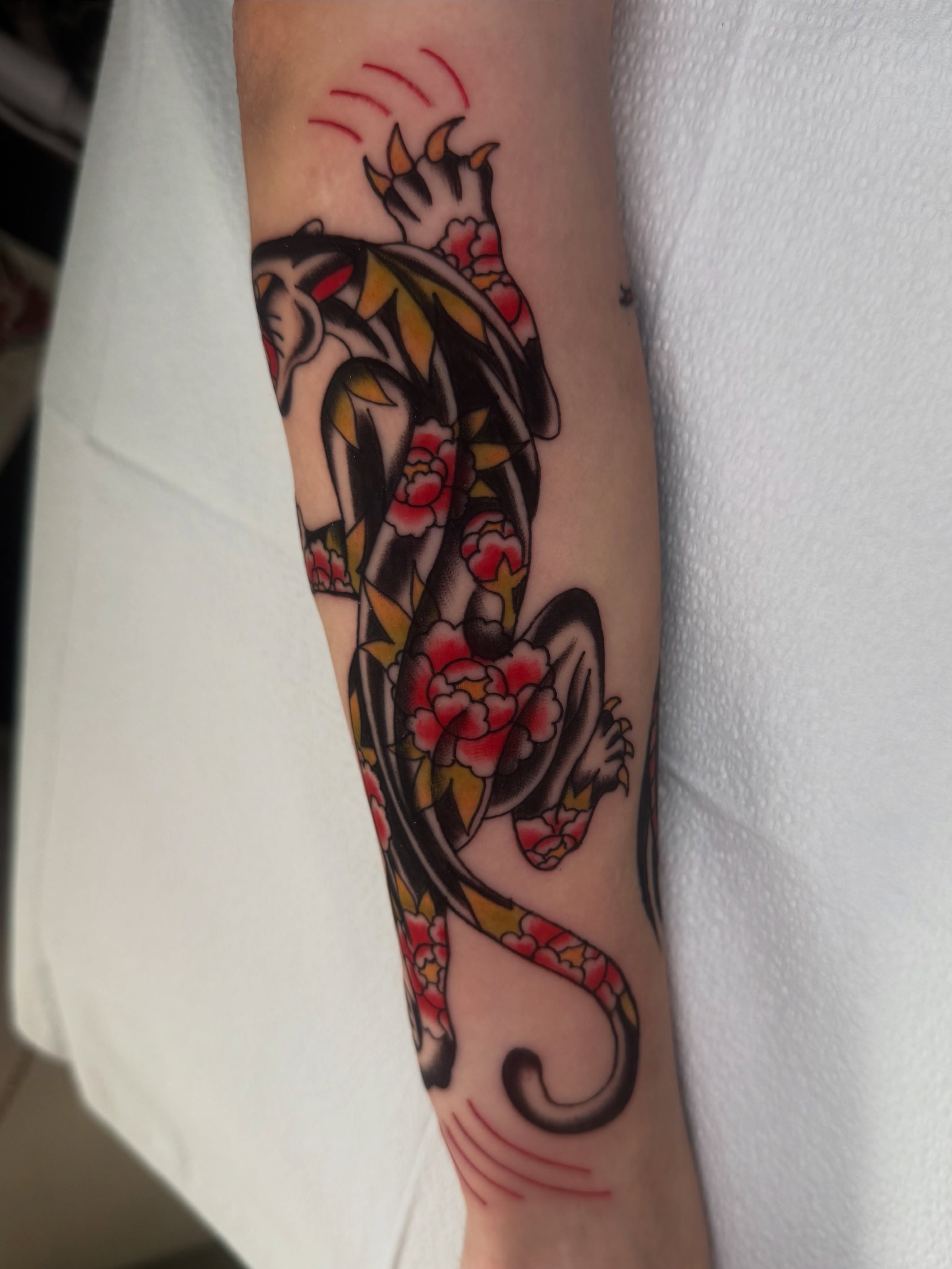 Dragon and flowers American traditional tattoo on the forearm by Lexie Graff