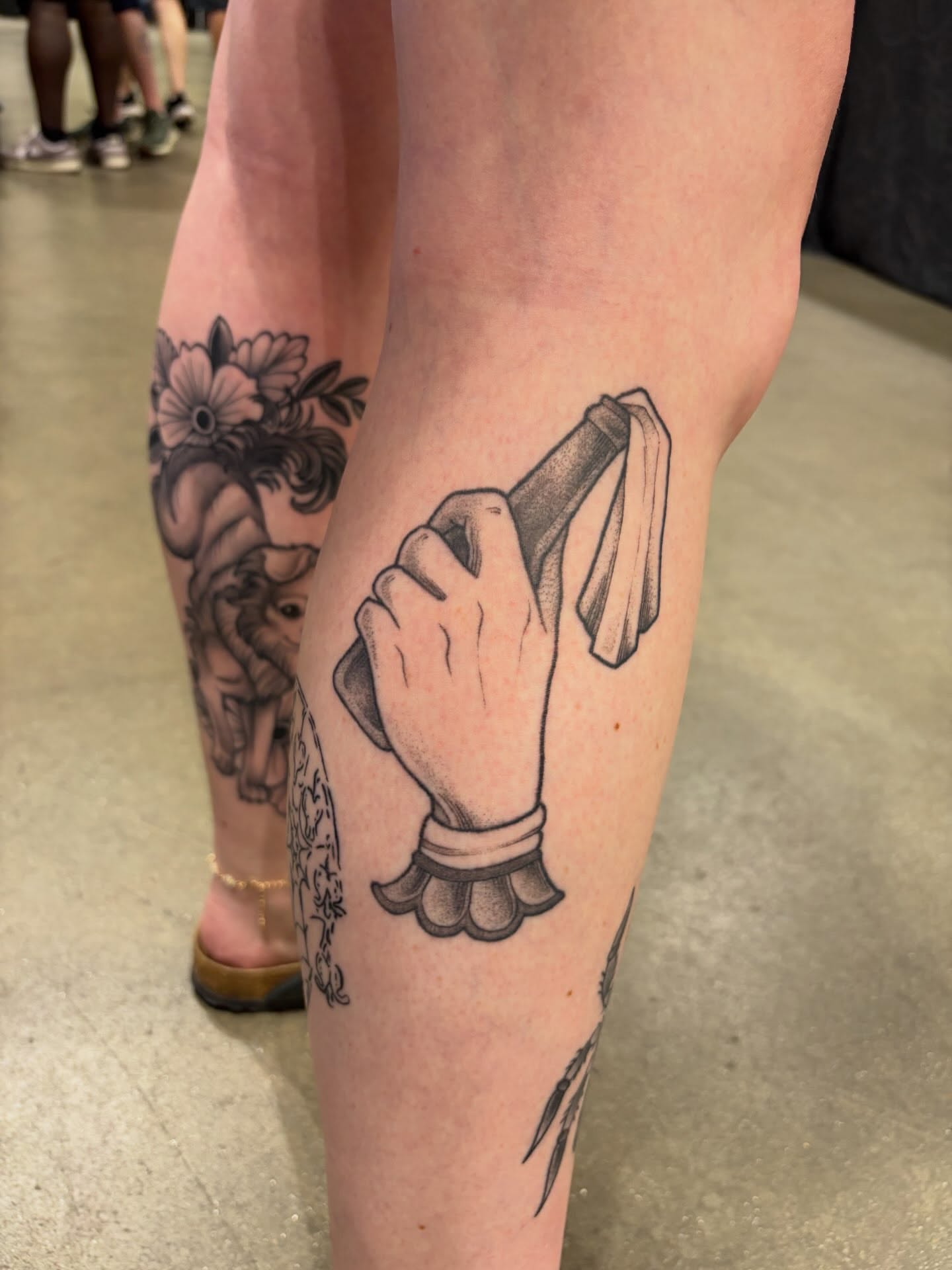 Hand holding bottle black and grey tattoo on the leg by bunny, Minneapolis, Minnesota