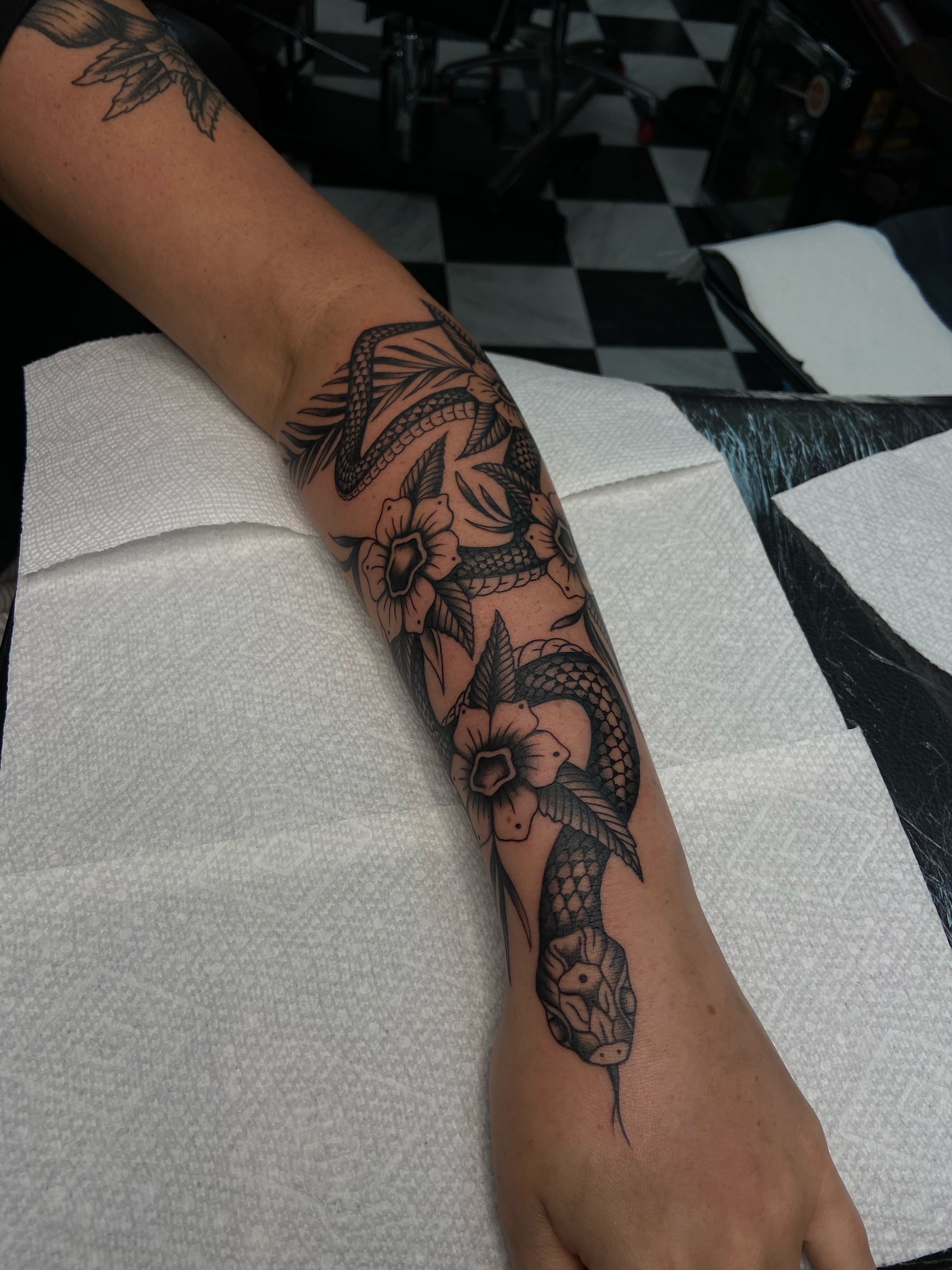 Snake and flowers American traditional tattoo on the forearm by R y a n S m i t h